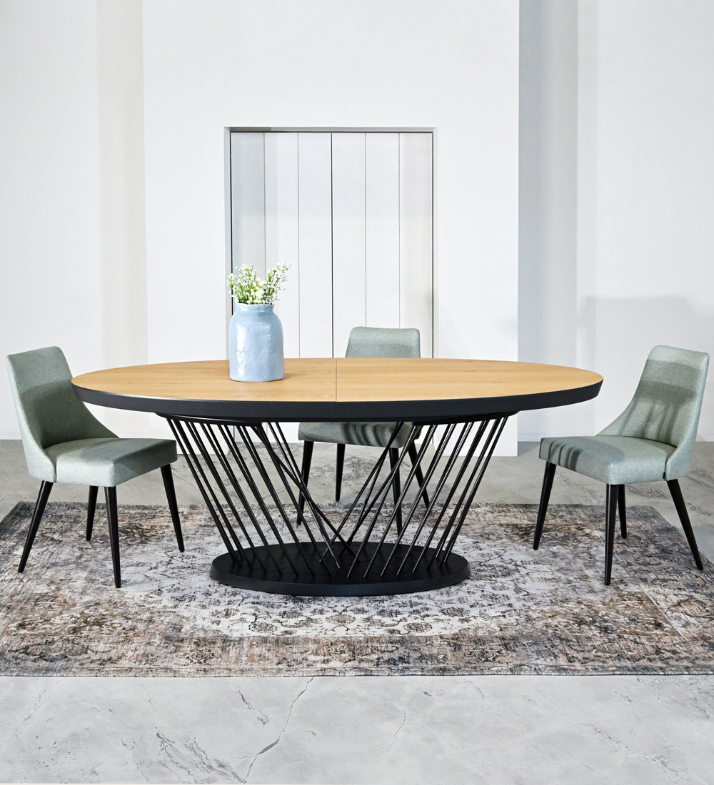 Table de repas ovale extensible avec plateau en chêne naturel et pieds et base en métal laqué noir.
