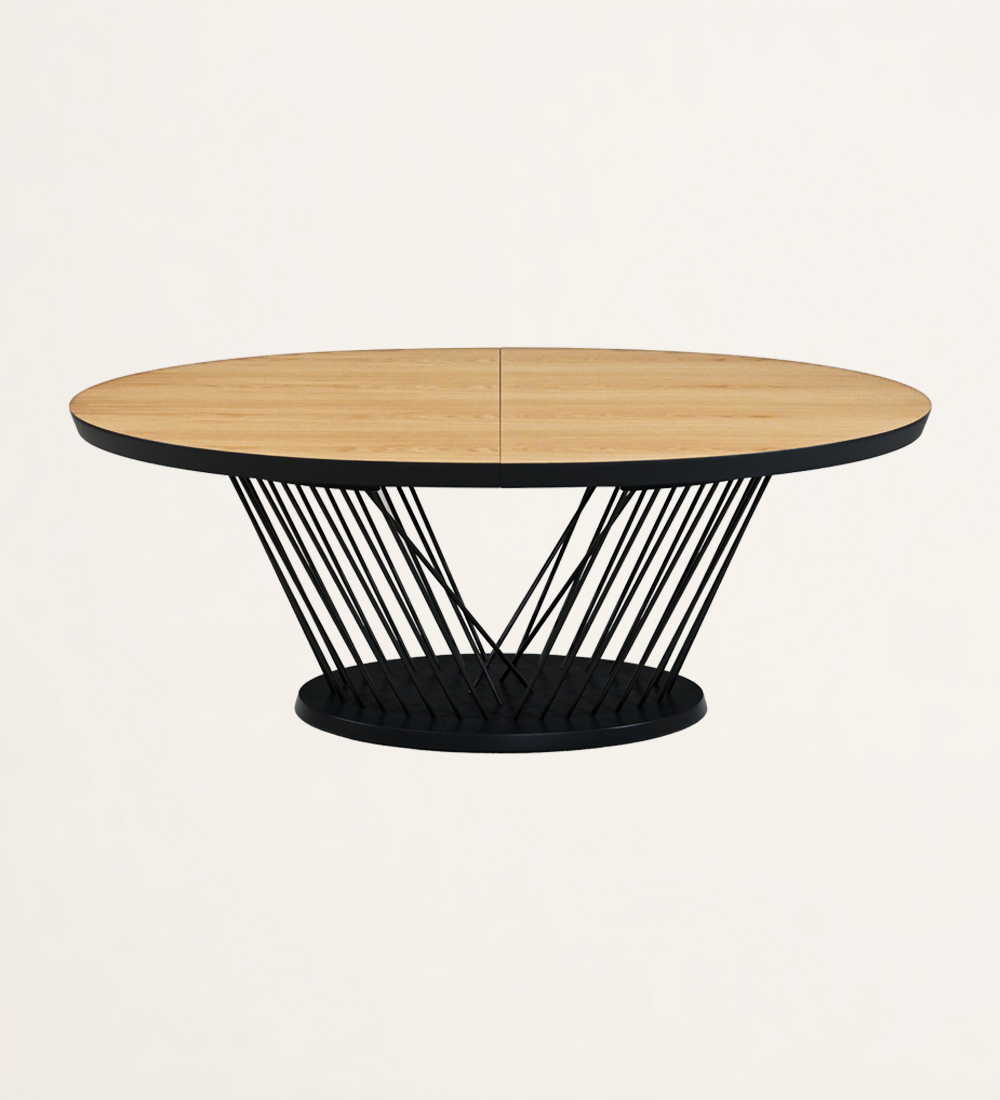 Table de repas ovale extensible avec plateau en chêne naturel et pieds et base en métal laqué noir.
