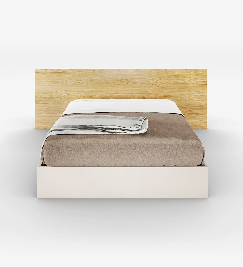 Lit double avec tête de lit en chêne naturel et sommier perlé, avec rangement via un lit surélevé.