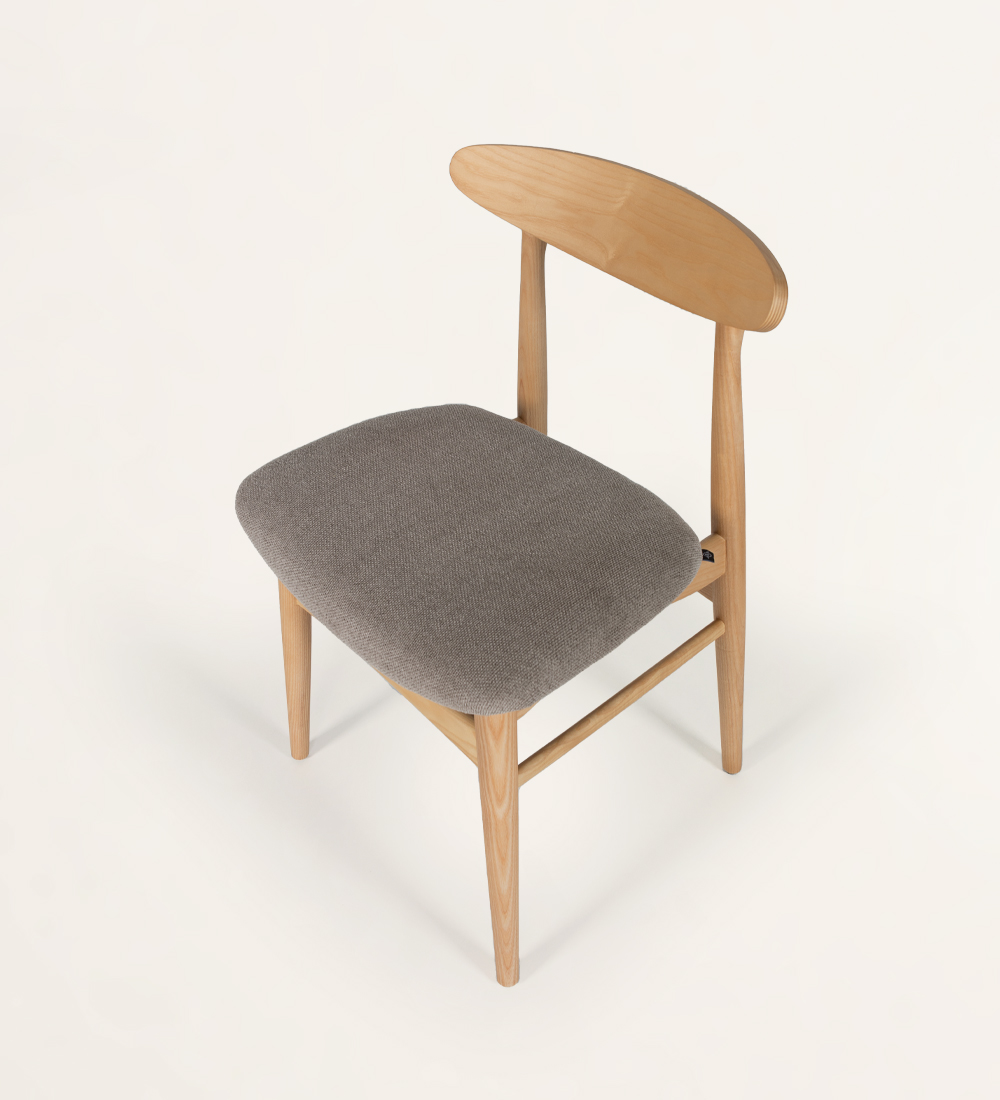 Chaise en bois de frêne, couleur naturelle, avec assise recouverte de tissu.