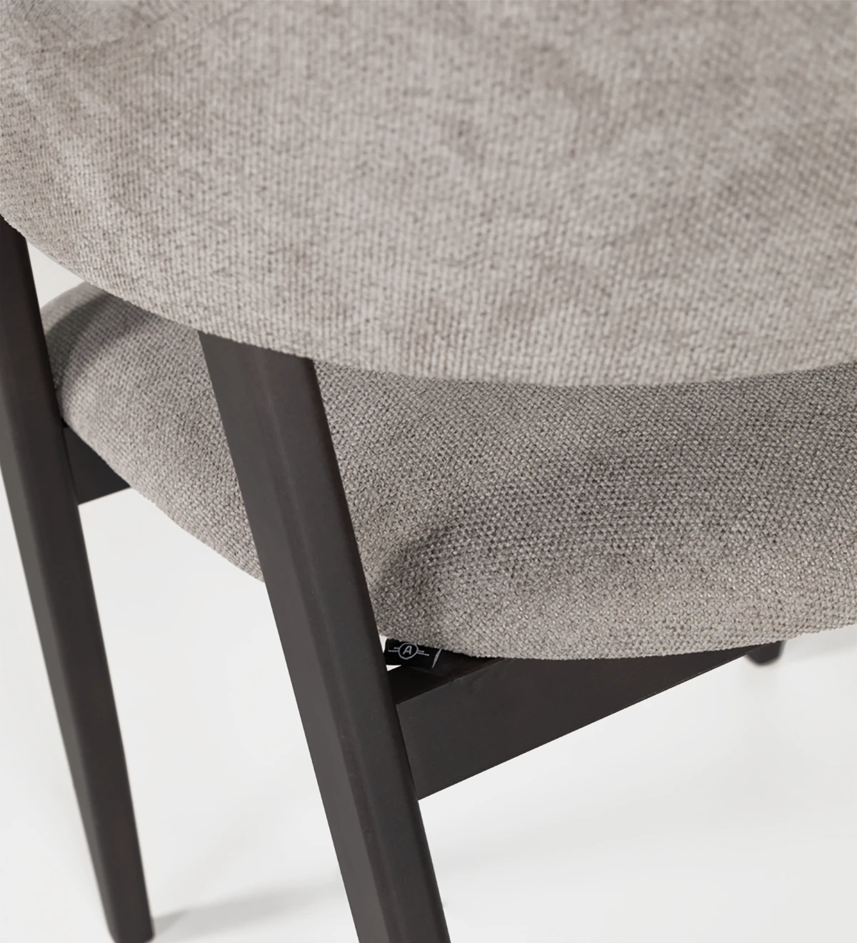 Silla de madera de fresno marrón oscuro con con brazos, asiento y respaldo tapizados en tejido.