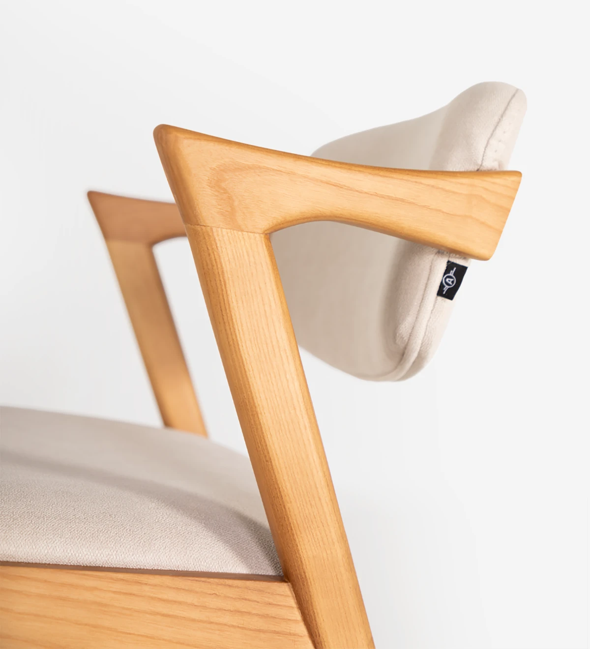 Silla en madera de fresno color miel, con asiento y respaldo tapizado en tejido.
