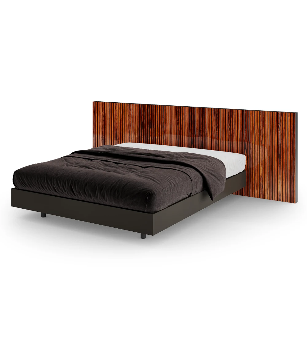 Double bed with headboard with friezes in high gloss palissander and suspended base in black.