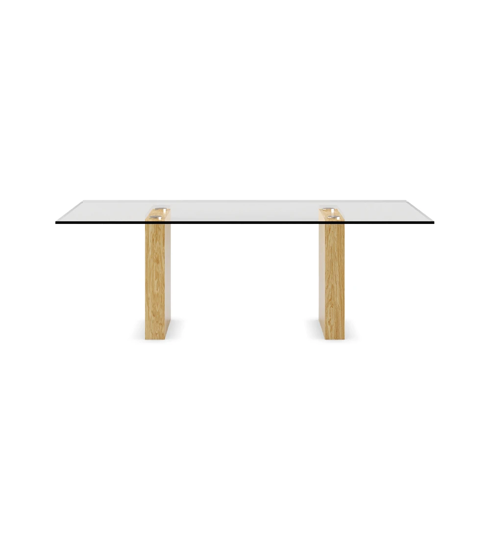 Mesa de comedor rectangular con tapa de cristal y pies de roble natural.