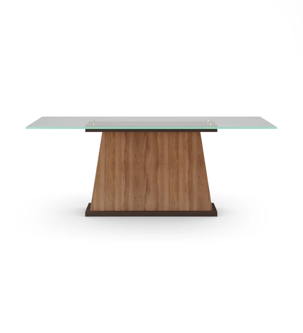 Mesa de comedor rectangular con tapa de cristal, pie central de nogal y base lacada en marrón oscuro.