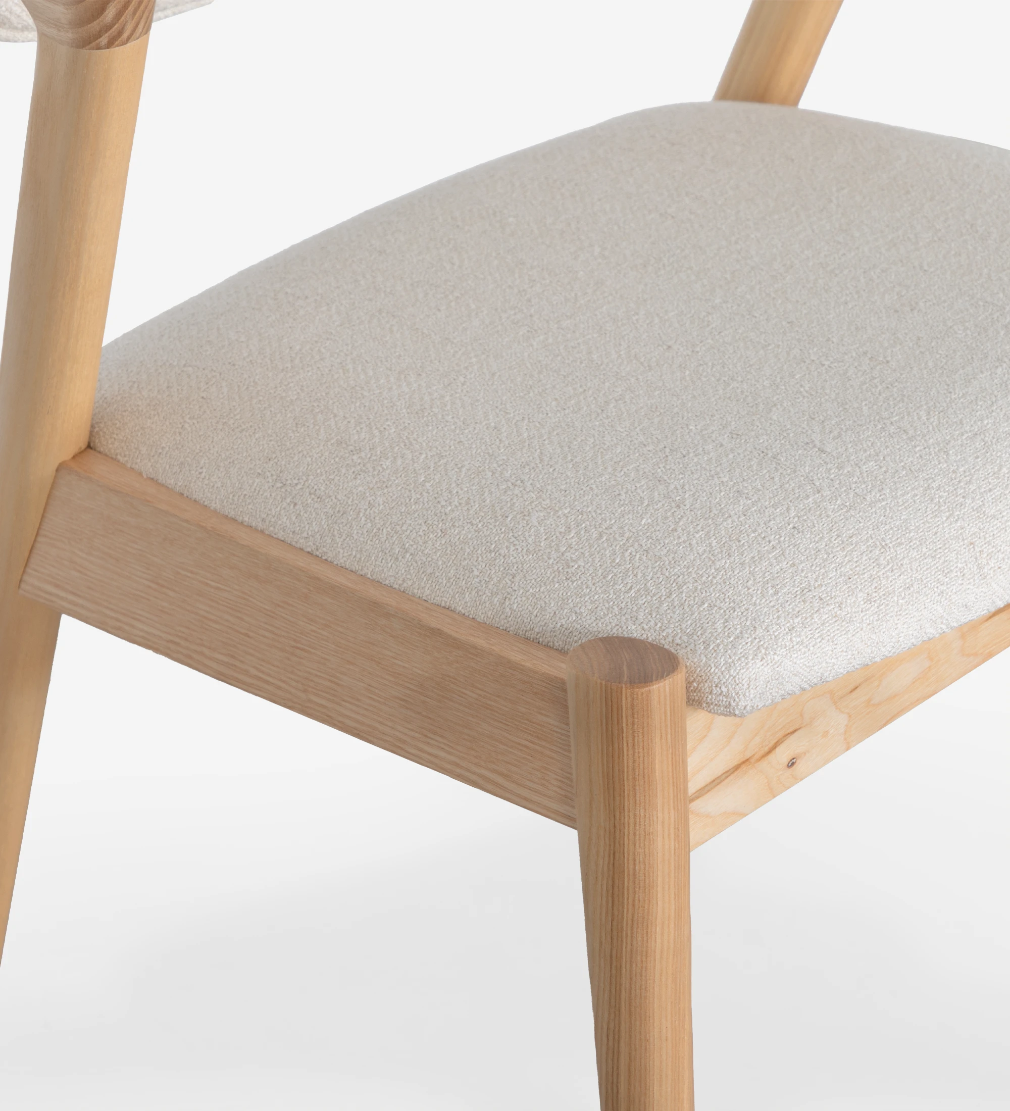 Silla en madera de fresno natural, con asiento y respaldo tapizados en tela