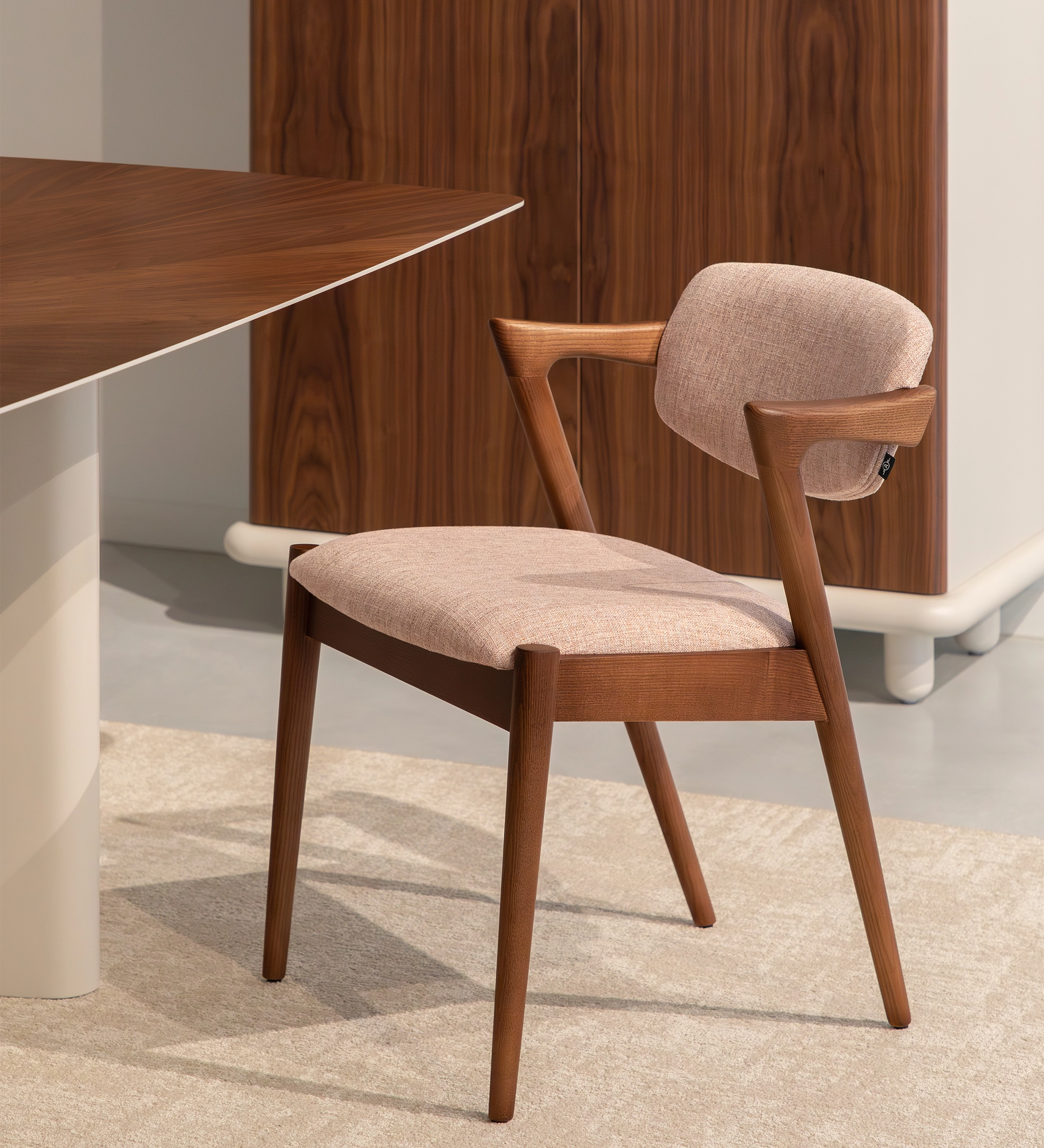 Elegante Cadeira Elba em salmão, destacando-se numa sala de jantar com decoração moderna