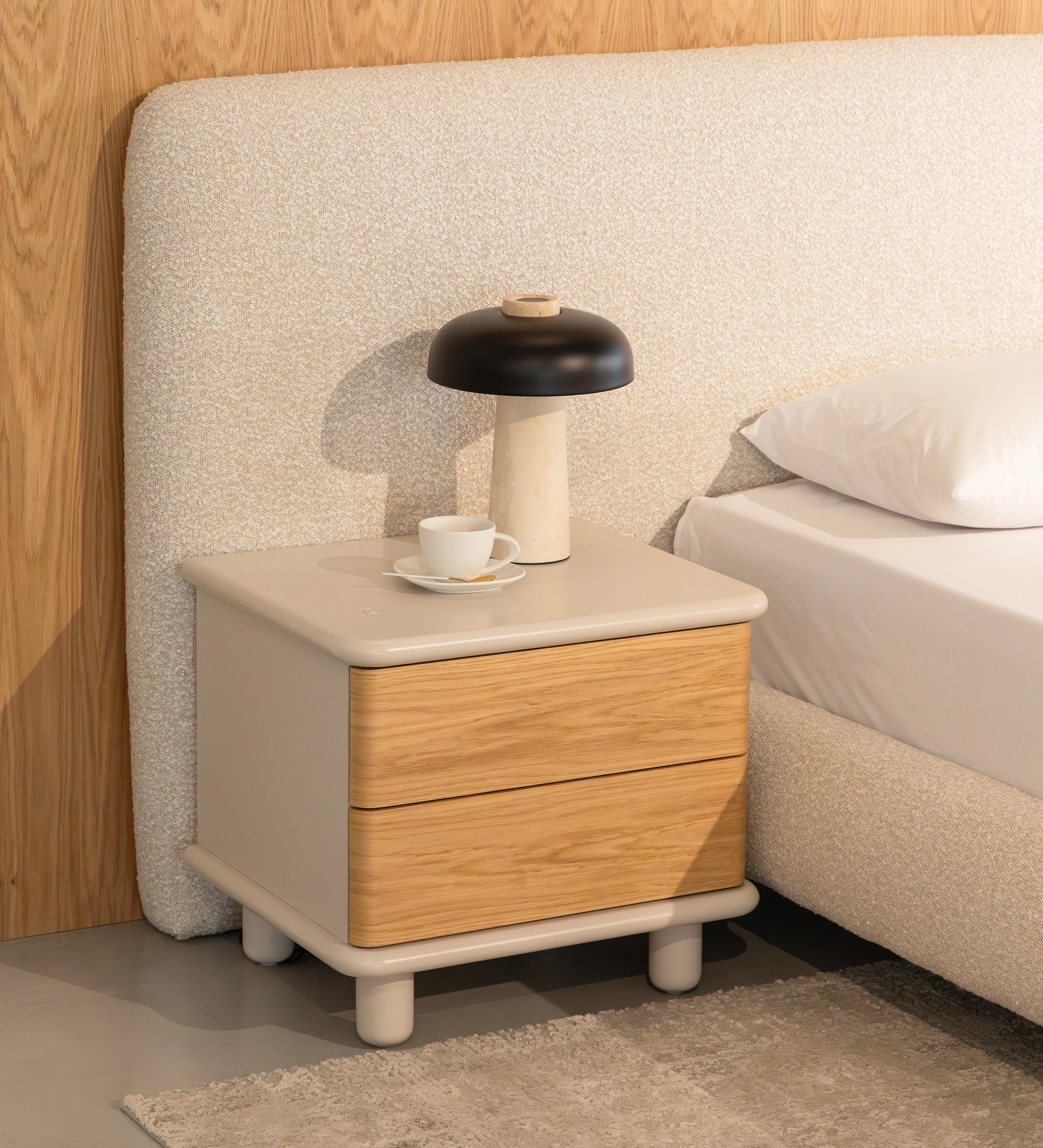 Candeeiro de Mesa HAIA com cúpula preta e base em pedra sobre mesa de cabeceira.