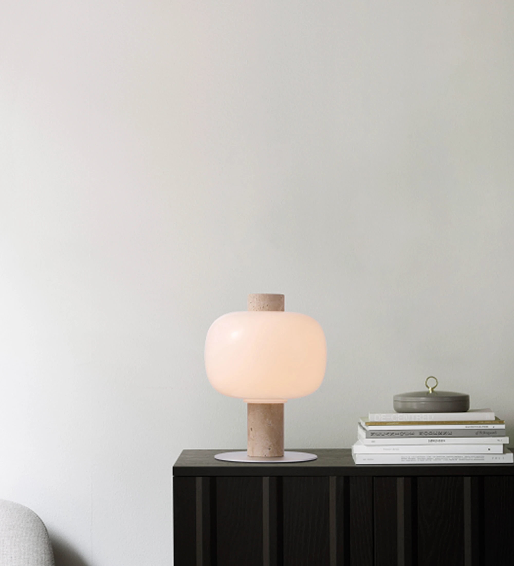 Table lamp with beige stone base and opal glass lampshade.