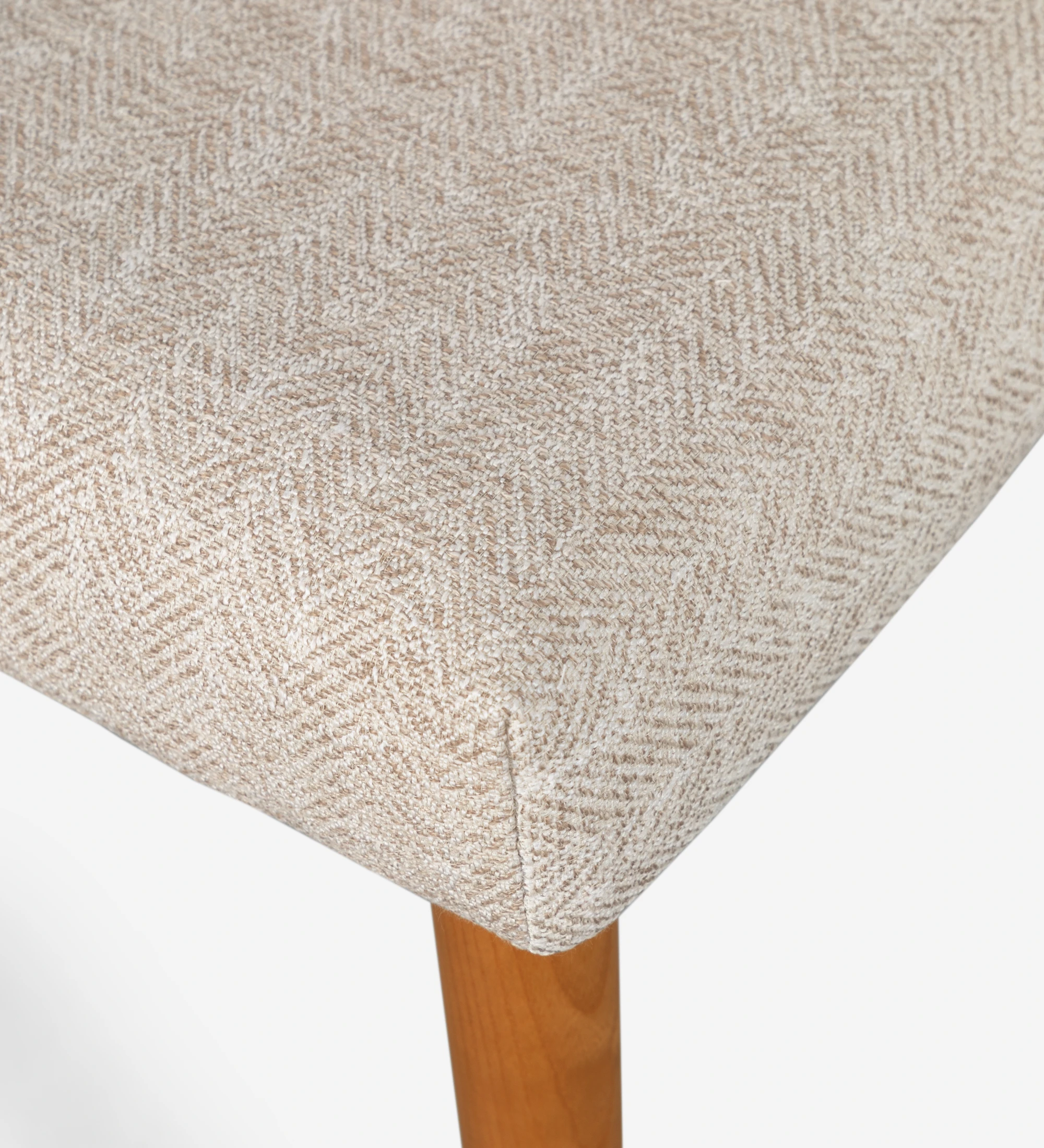 Silla Oslo tapizada en tela beige y patas de madera color miel.