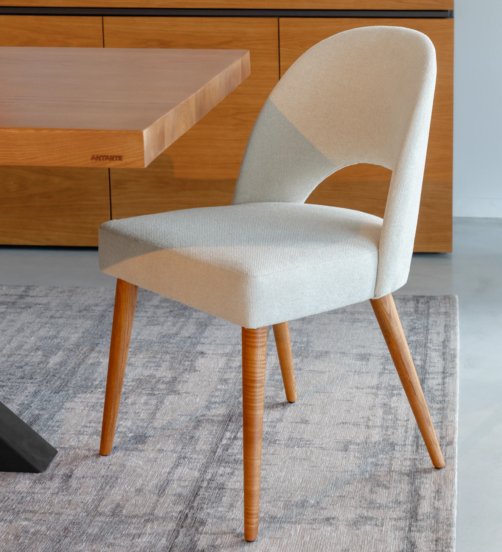 Chair upholstered in fabric, with honey-colored wooden legs.