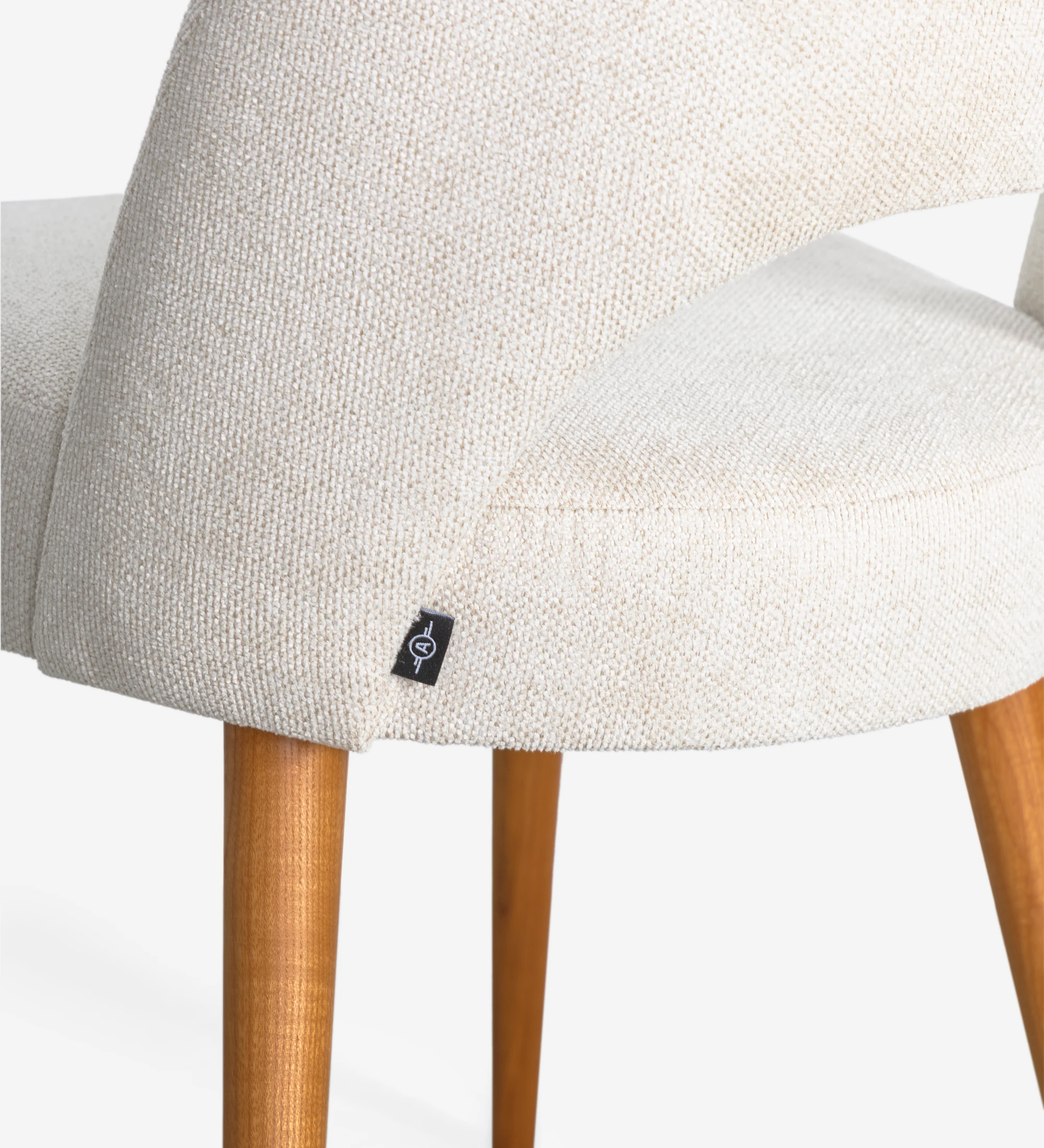 Chaise rembourré en tissu, avec pieds en bois couleur miel.