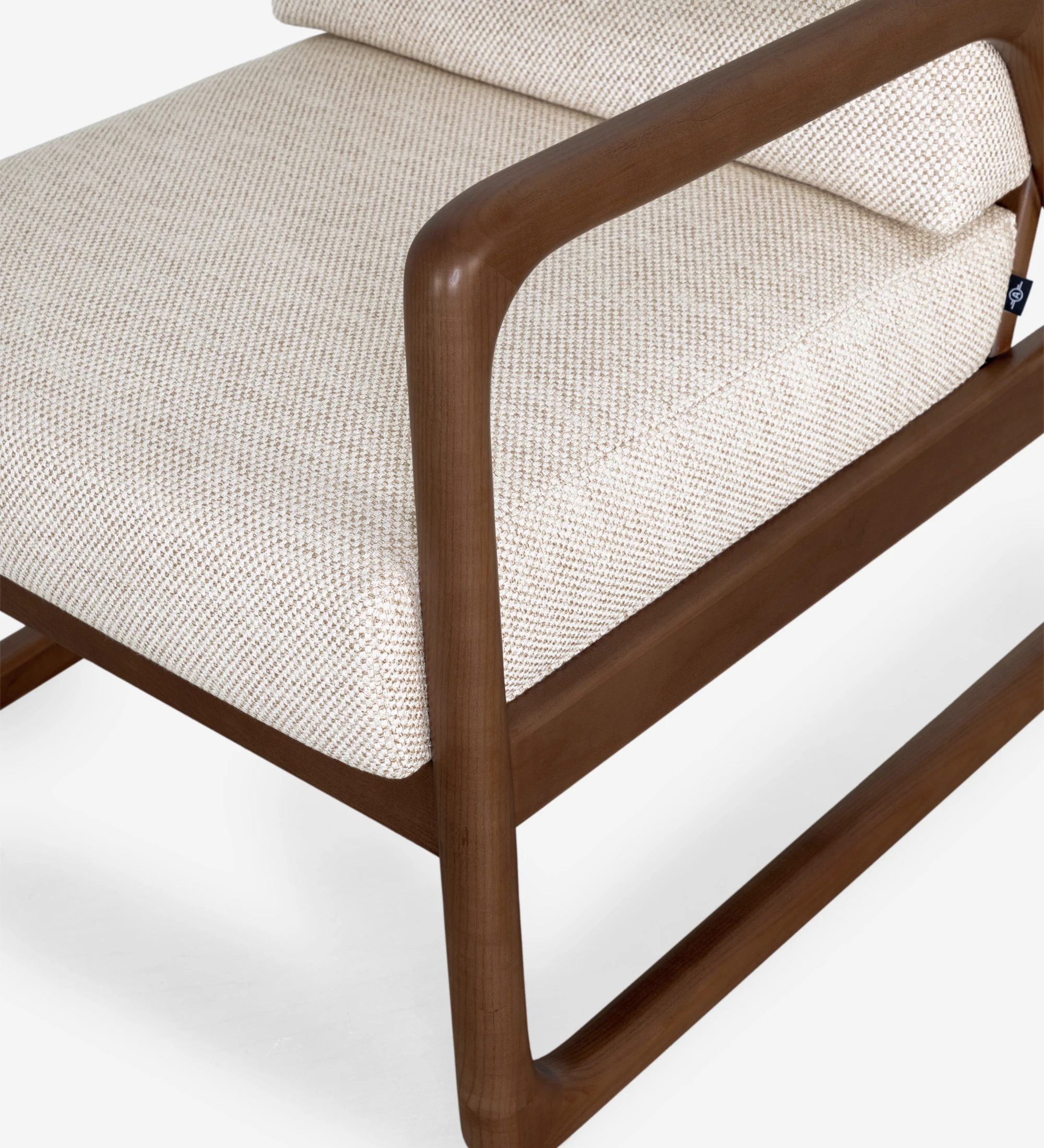 Fauteuil Antarte by IA recouvert en tissu beige, structure en bois couleur noyer.