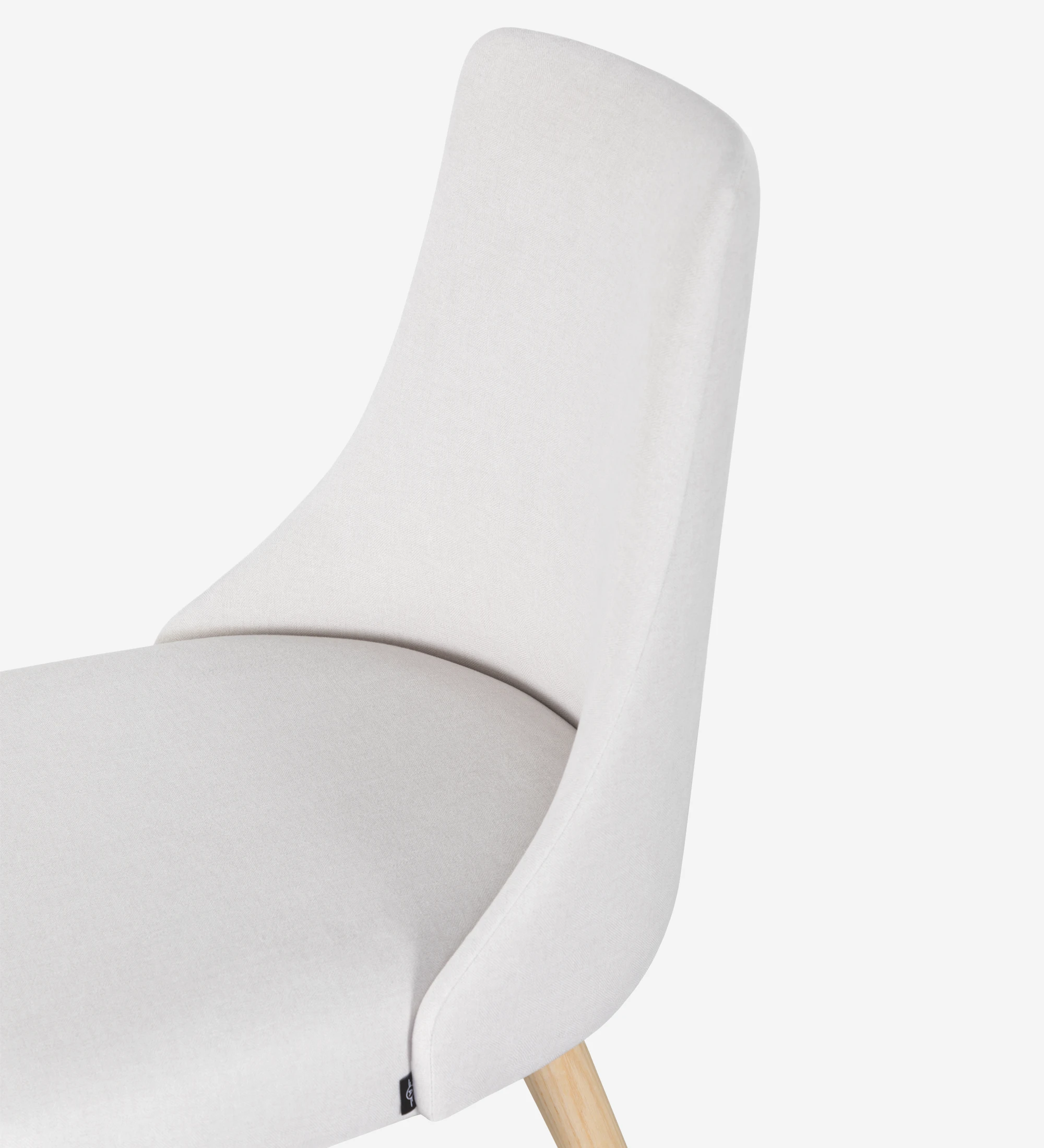 Chaise Oslo tapissée de tissu blanc et pieds en bois de couleur naturelle.