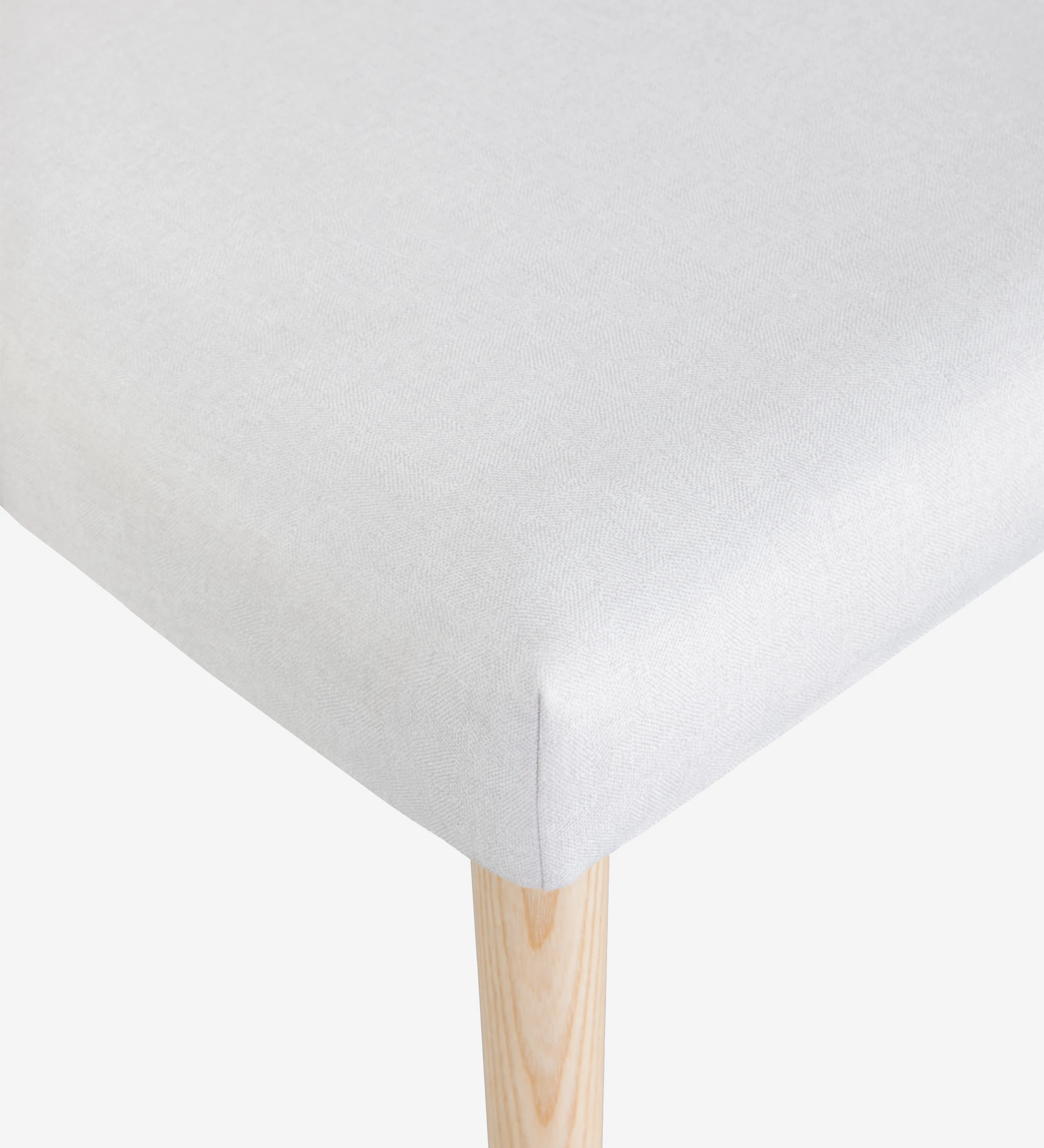 Chaise Oslo tapissée de tissu blanc et pieds en bois de couleur naturelle.