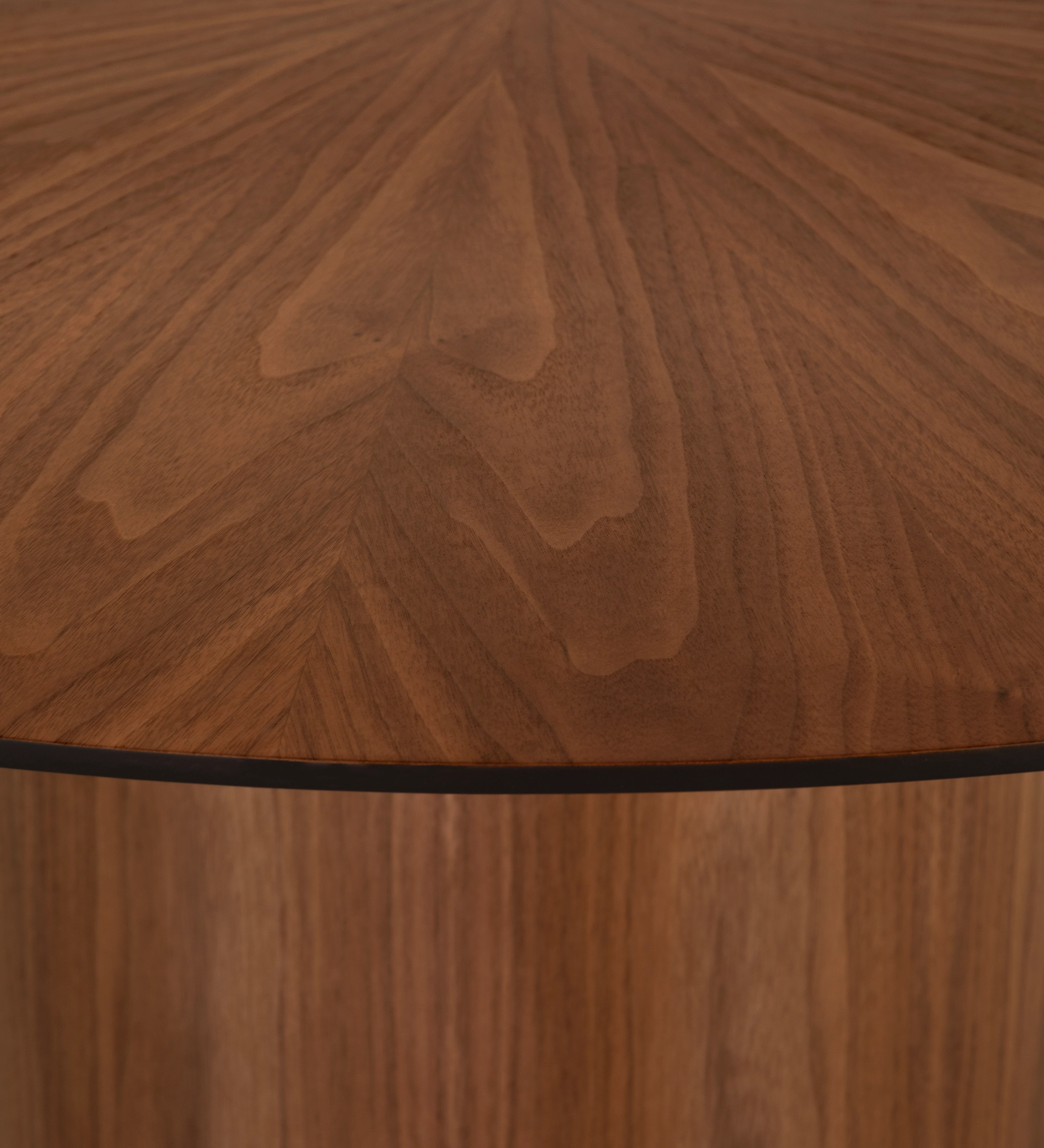 Mesa de jantar Geneve redonda Ø 130 cm, tampo espinhado e pé em nogueira natural, pormenor do tampo lacado a negro.