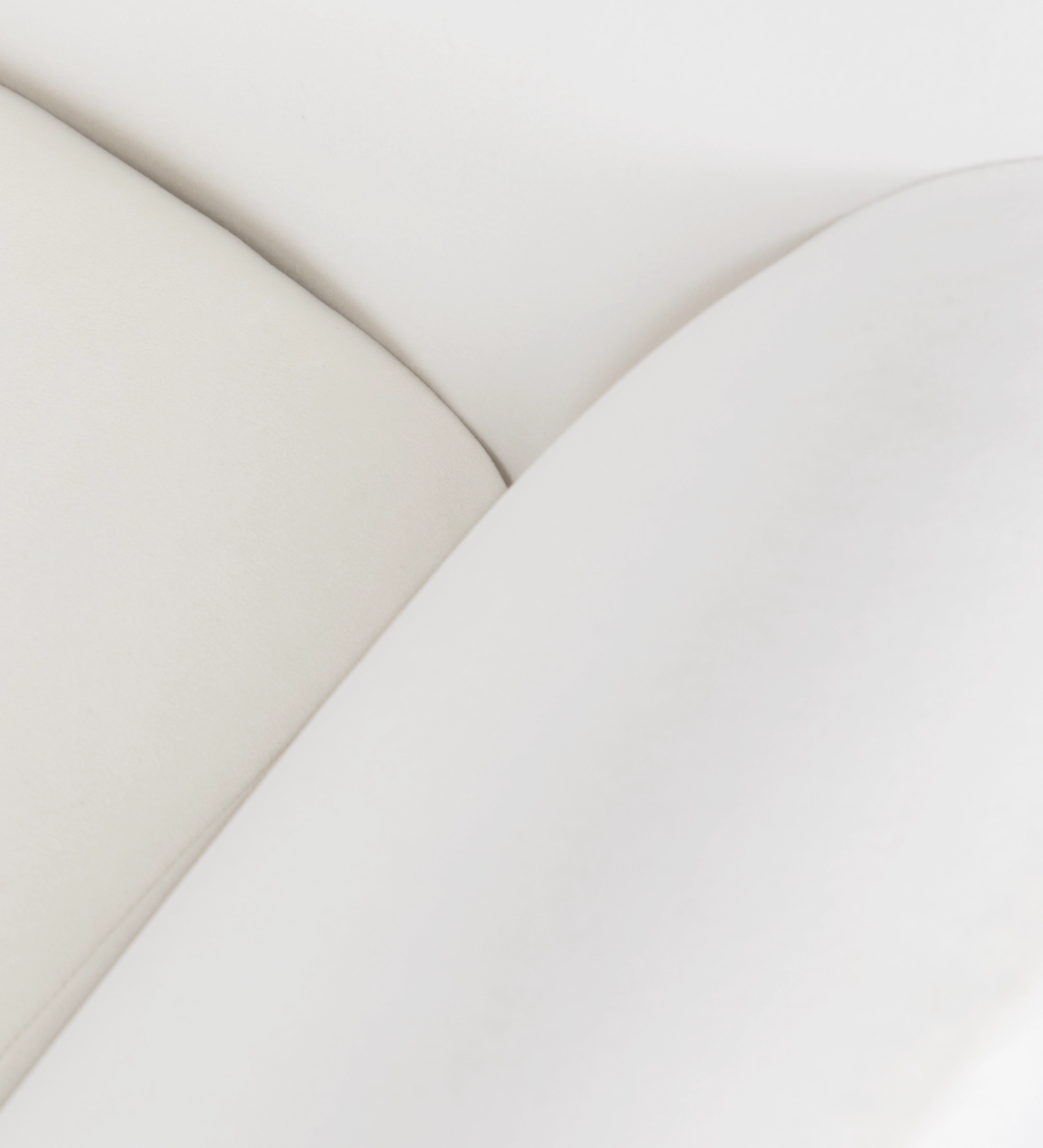 Fauteuil Oslo revêtu de tissu couleur perle avec pieds en frêne teinté noyer.
