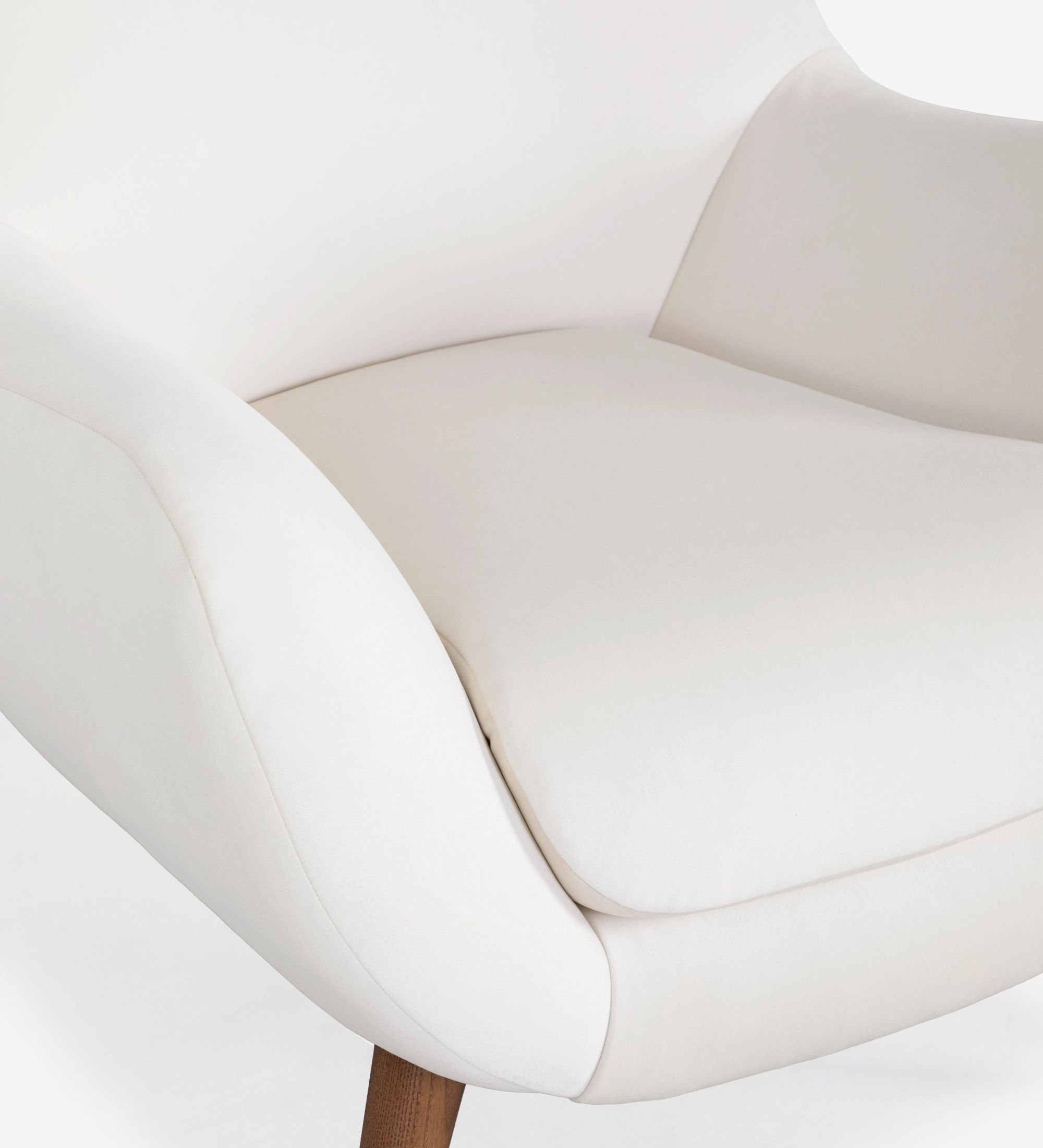 Fauteuil Oslo revêtu de tissu couleur perle avec pieds en frêne teinté noyer.