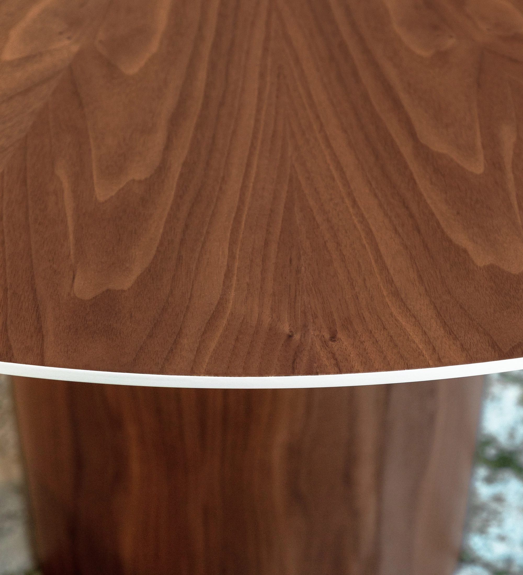 Mesa de jantar Geneve redonda Ø 130 cm, tampo espinhado e pé em nogueira natural, pormenor do tampo lacado a pérola.