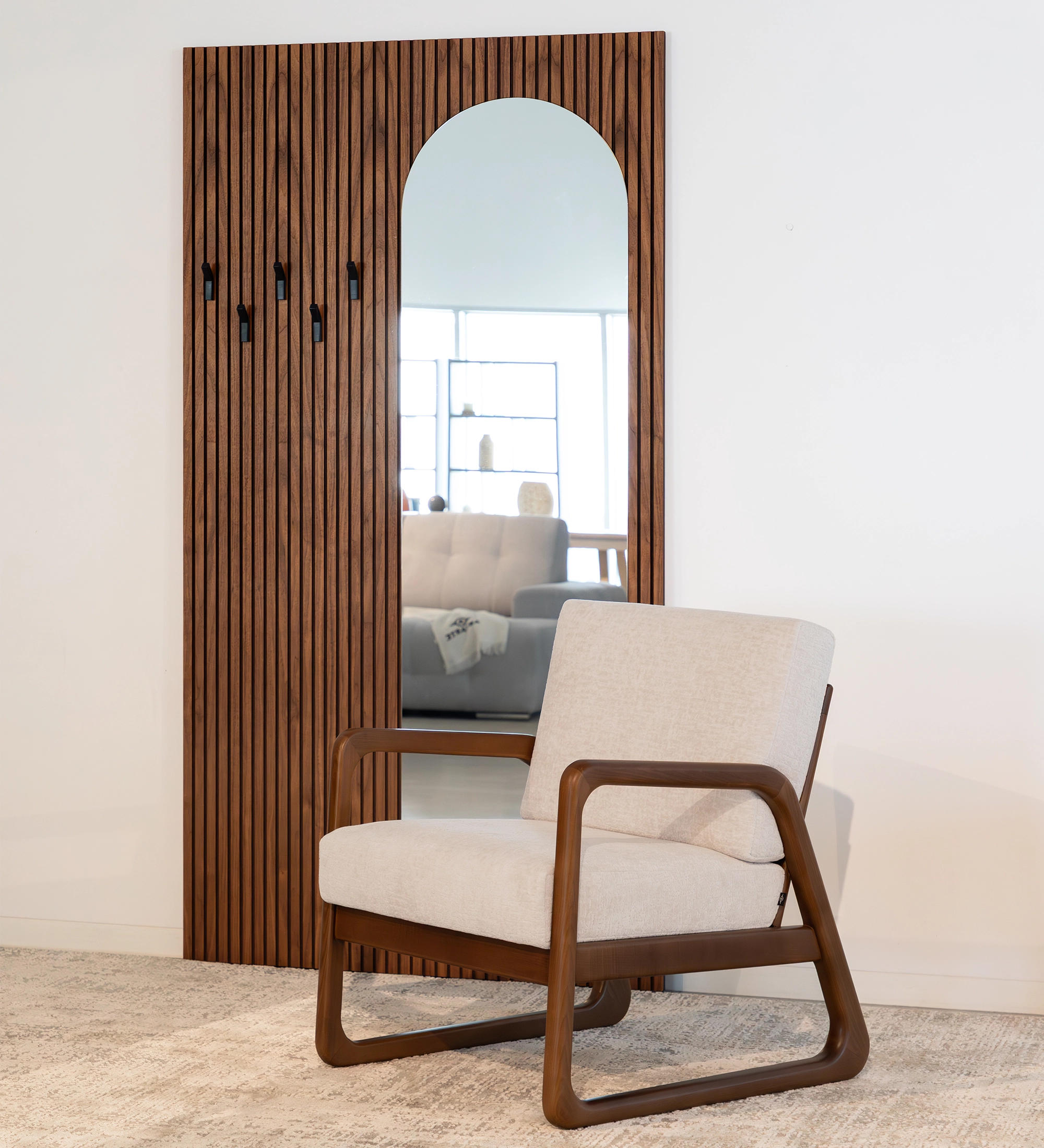 Fauteuil Antarte by IA recouvert en tissu perle, structure en bois couleur noyer.