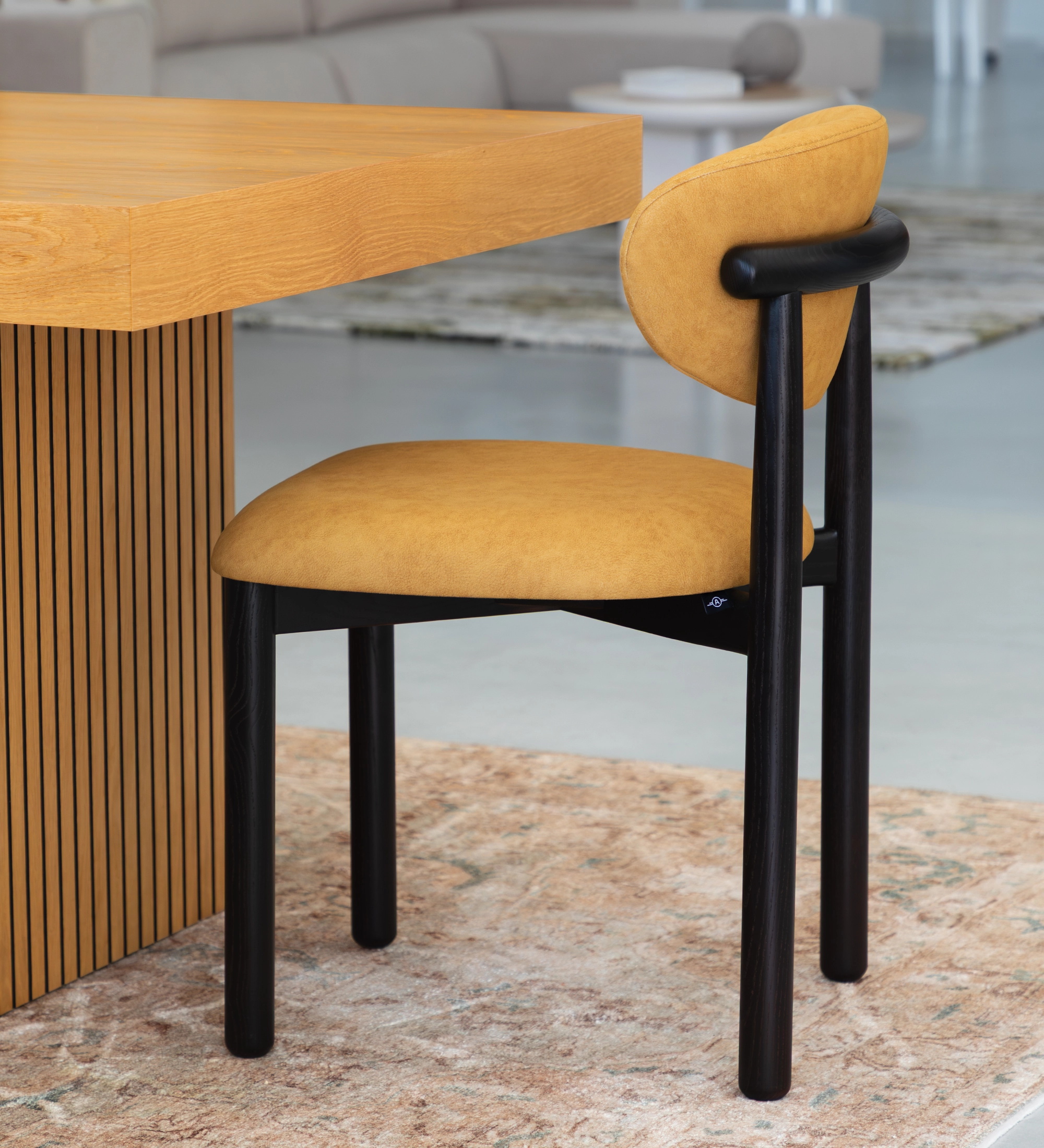 Silla de madera de fresno en color wengué, con asiento y respaldo tapizados en tela amarilla.