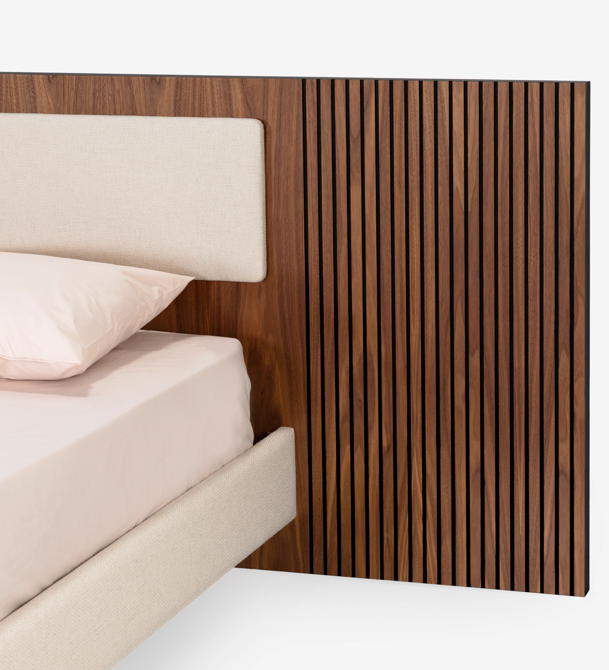 Cama doble con panel central del cabecero y base suspendida tapizados en tejido beige, laterales del cabecero con molduras de nogal natural.