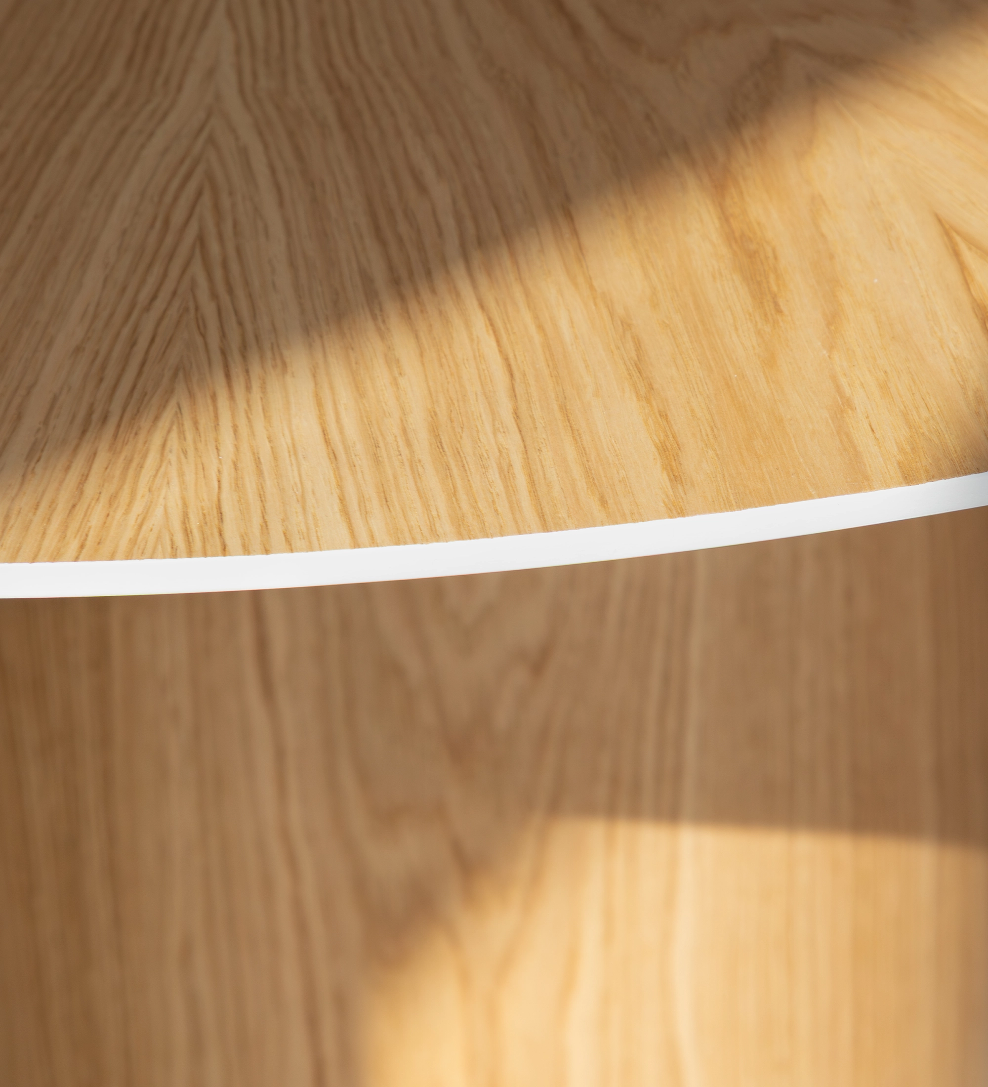 Geneve round dining table Ø 130 cm, sunburst top and natural oak base, with pearl lacquered top detail.