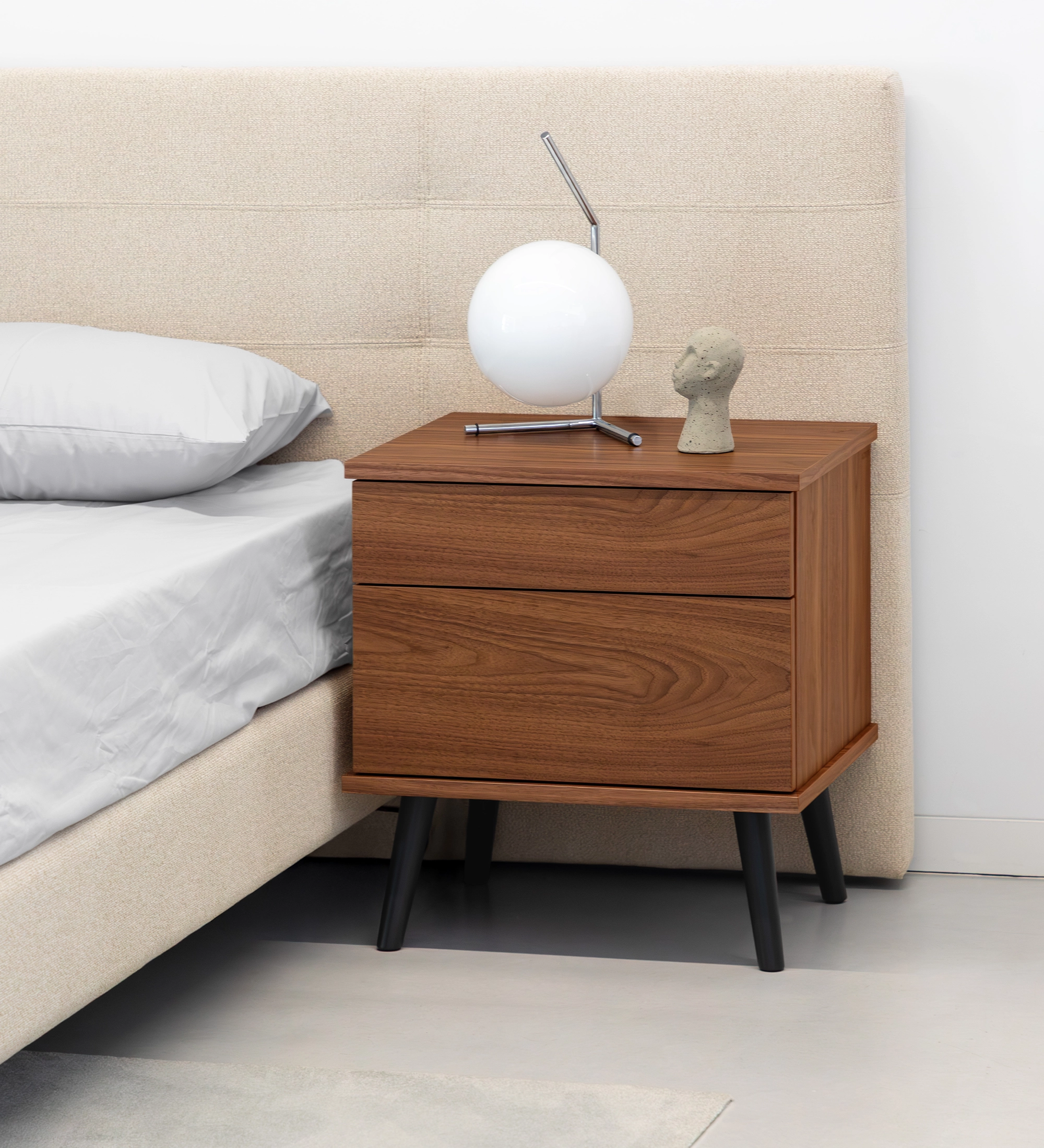 Oslo bedside table with 2 drawers and structure in natural walnut veneer. Black lacquered legs. Dimensions: 55 x 57.5 cm.