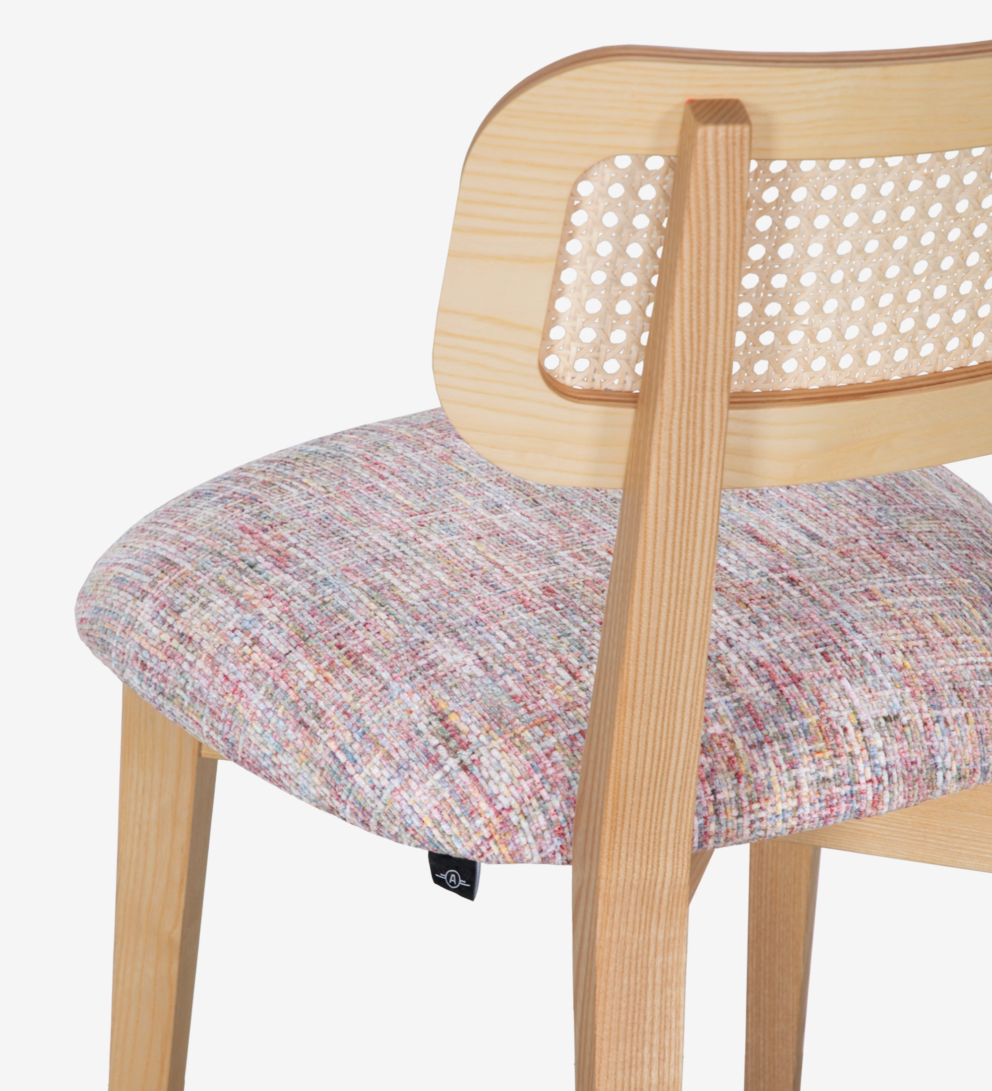 Cadeira de madeira, com pormenor de rattan nas costas e assento estofado a tecido multicolor, primariamente magenta.