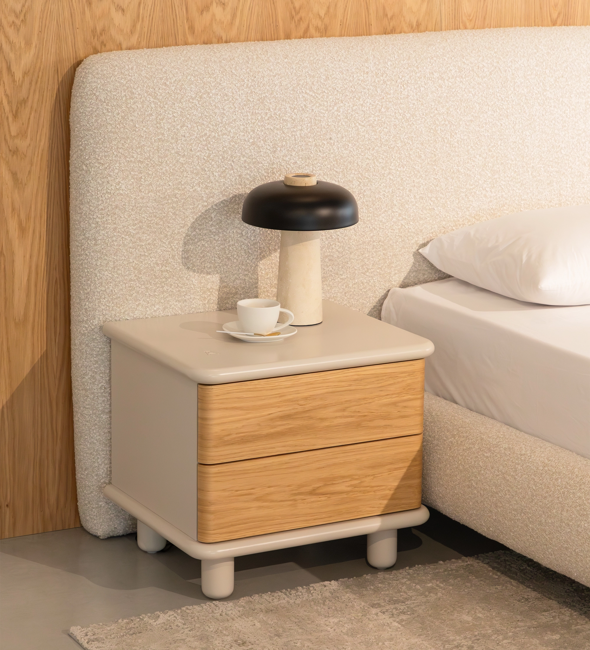 Paris bedside table with two oak drawers, white top, lamp and book next to bed
