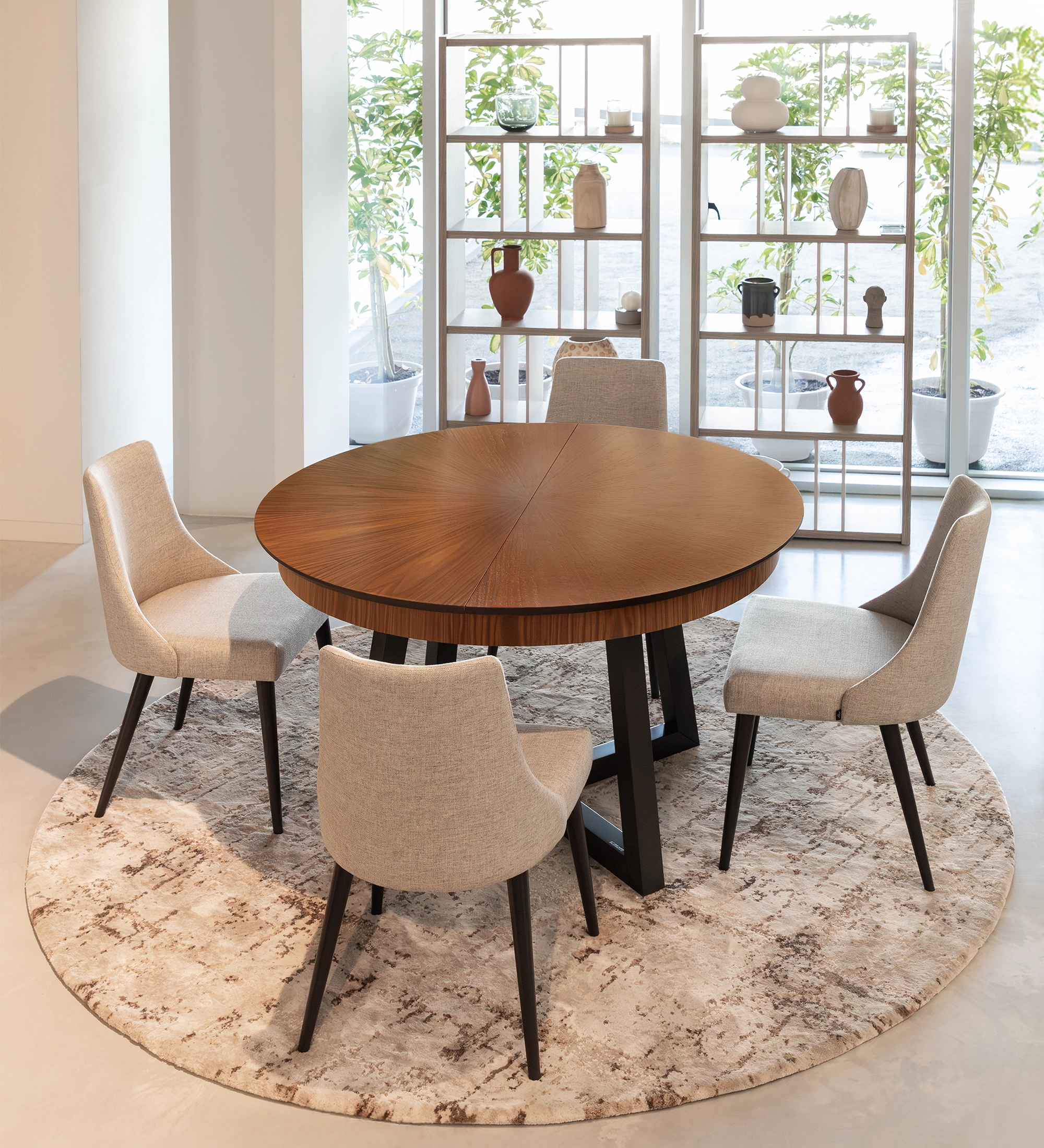 Round extendable dining table with natural walnut top and black lacquered legs.
