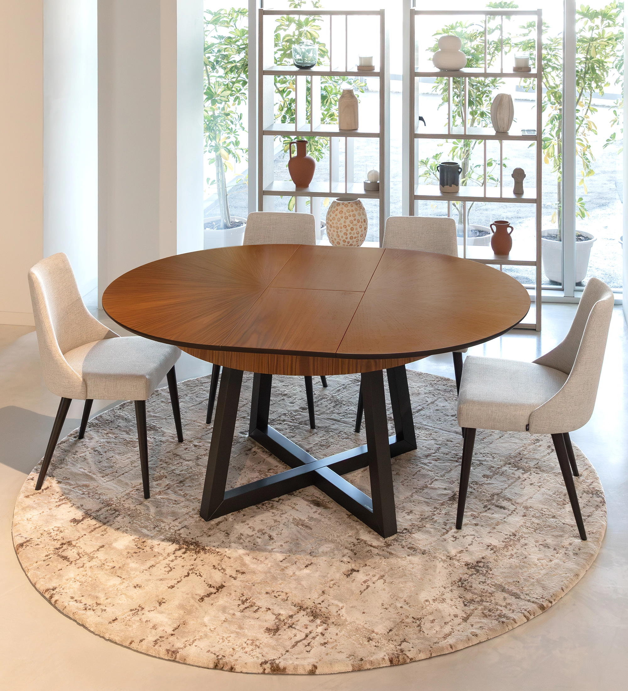 Round extendable dining table with natural walnut top and black lacquered legs.