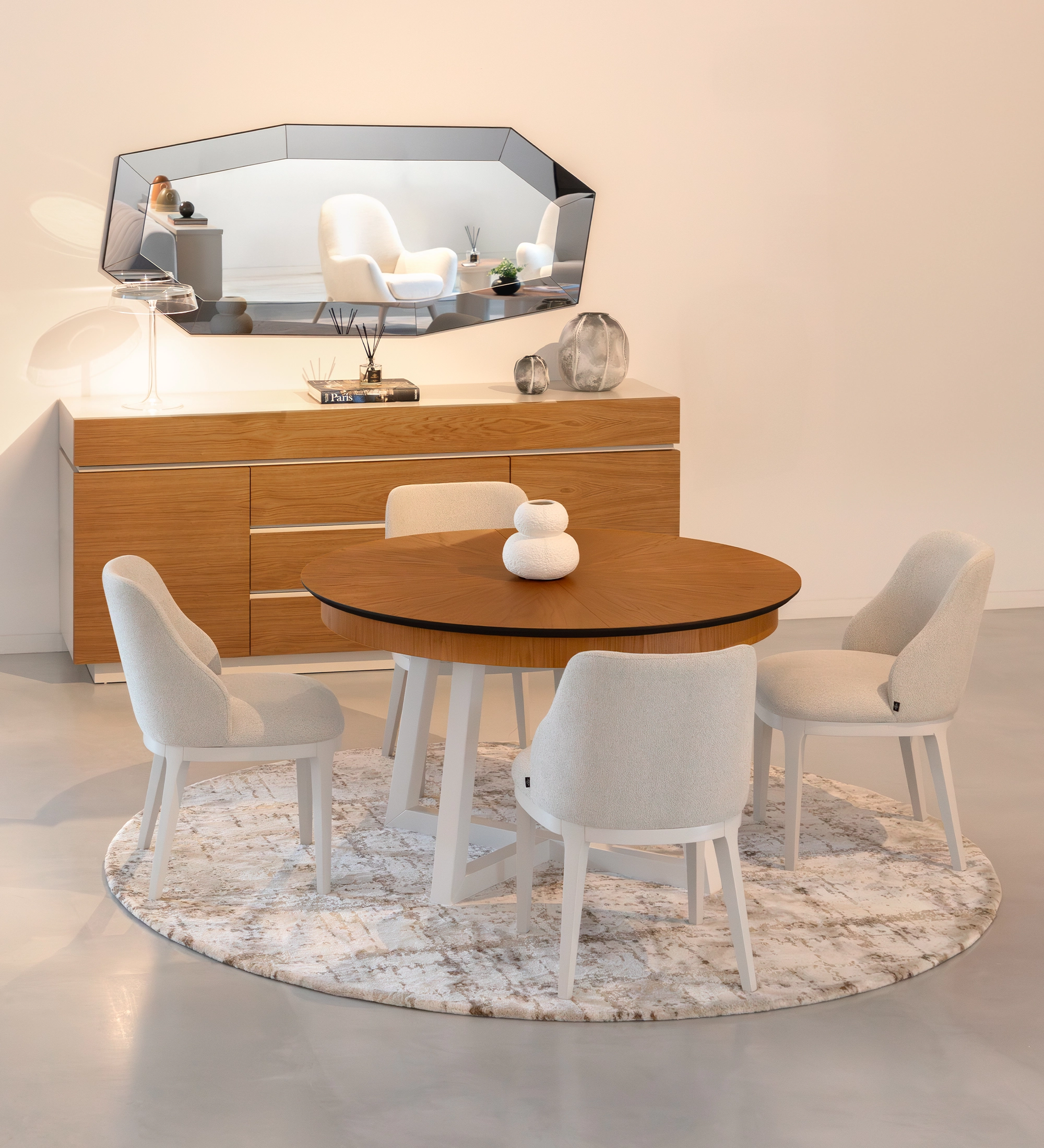 Mesa de comedor redonda extensible con tablero de roble miel y patas lacadas en perla.