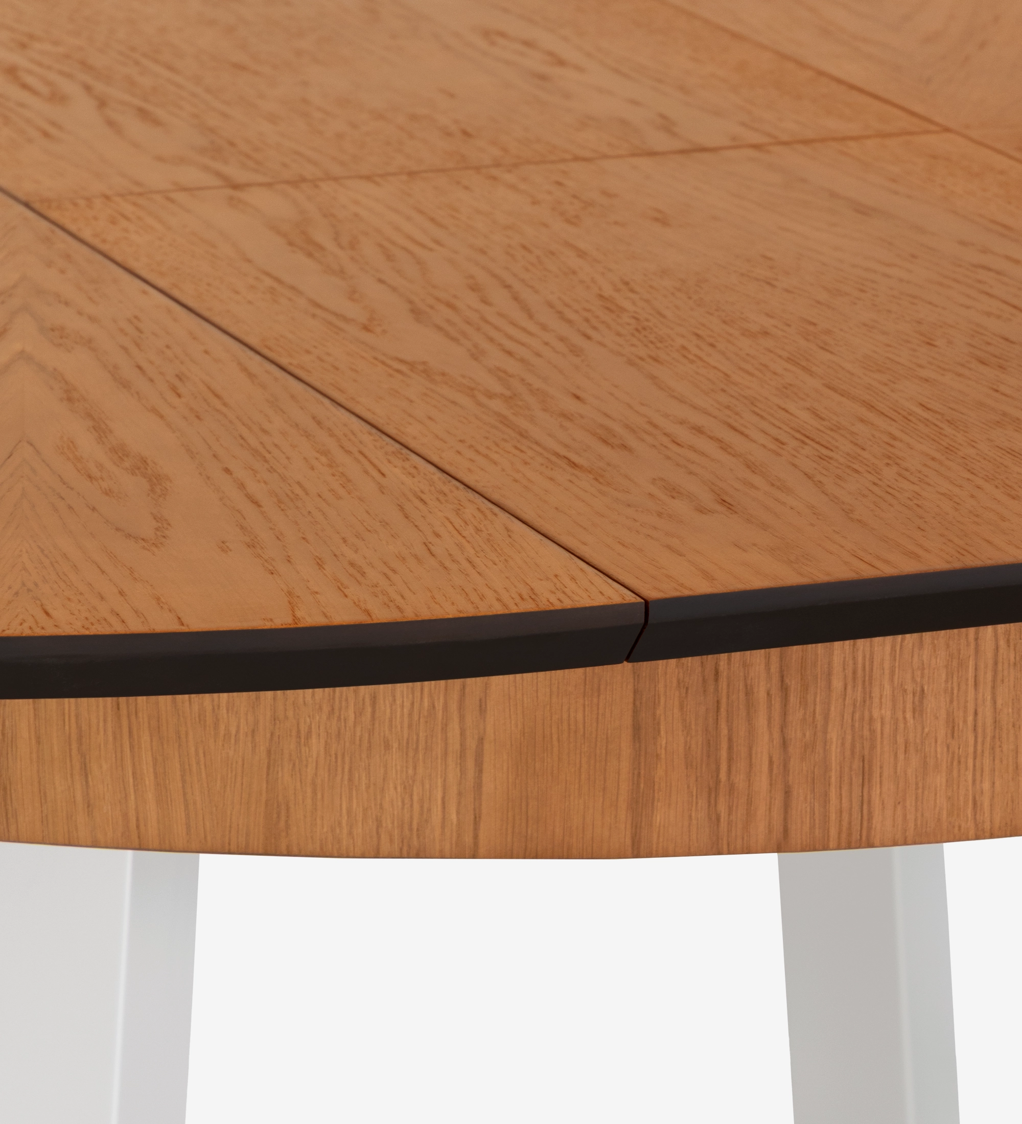 Mesa de comedor redonda extensible con tablero de roble miel y patas lacadas en perla.