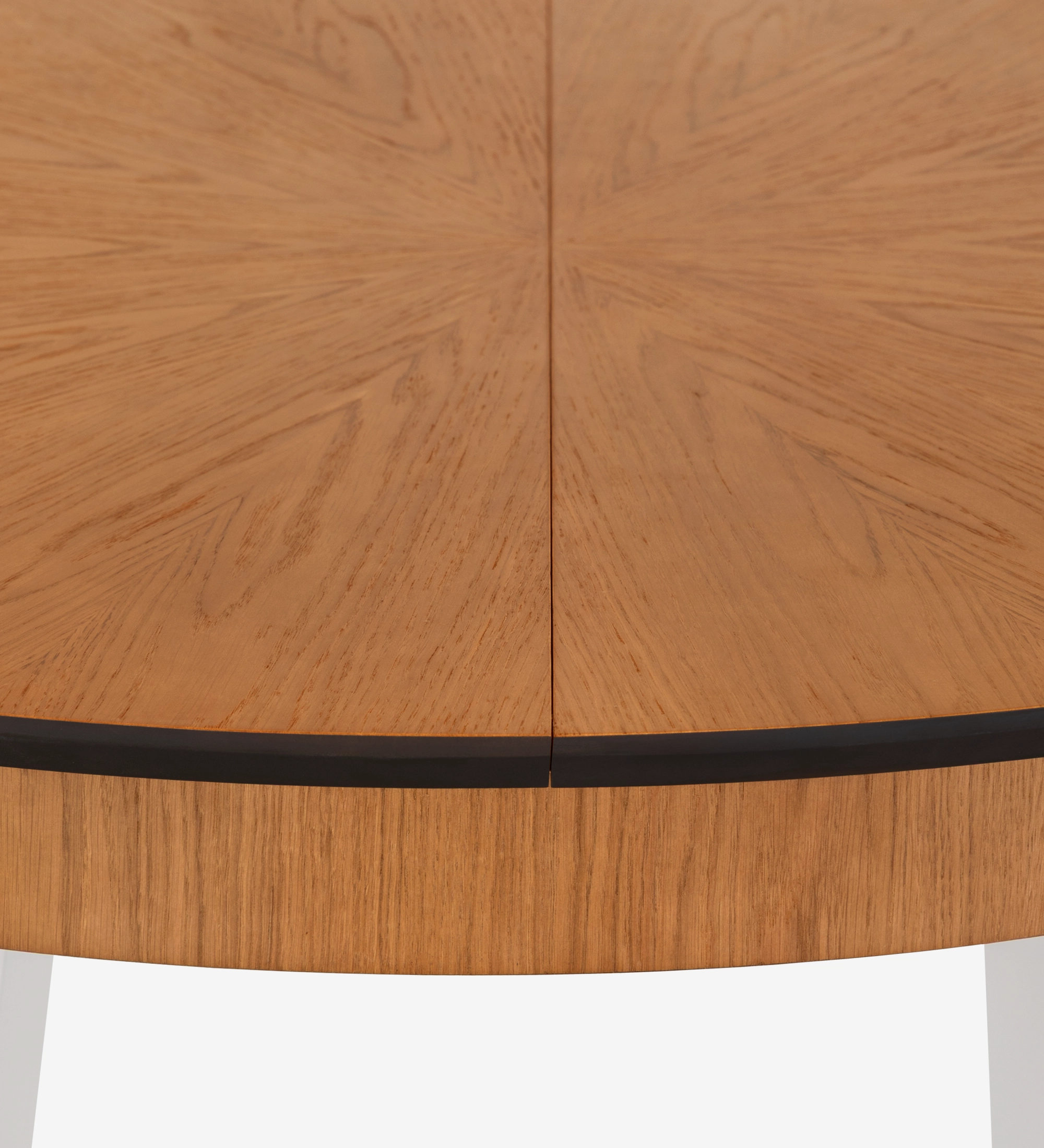 Mesa de comedor redonda extensible con tablero de roble miel y patas lacadas en perla.