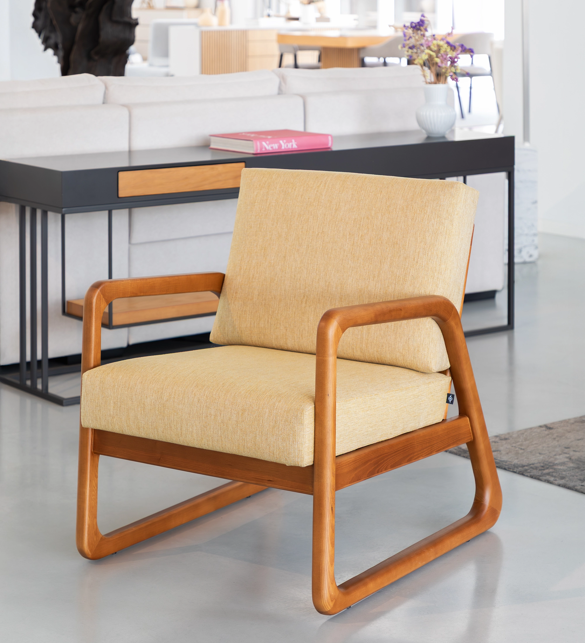 Fauteuil Antarte by IA recouvert en tissu jaune, structure en bois couleur miel.