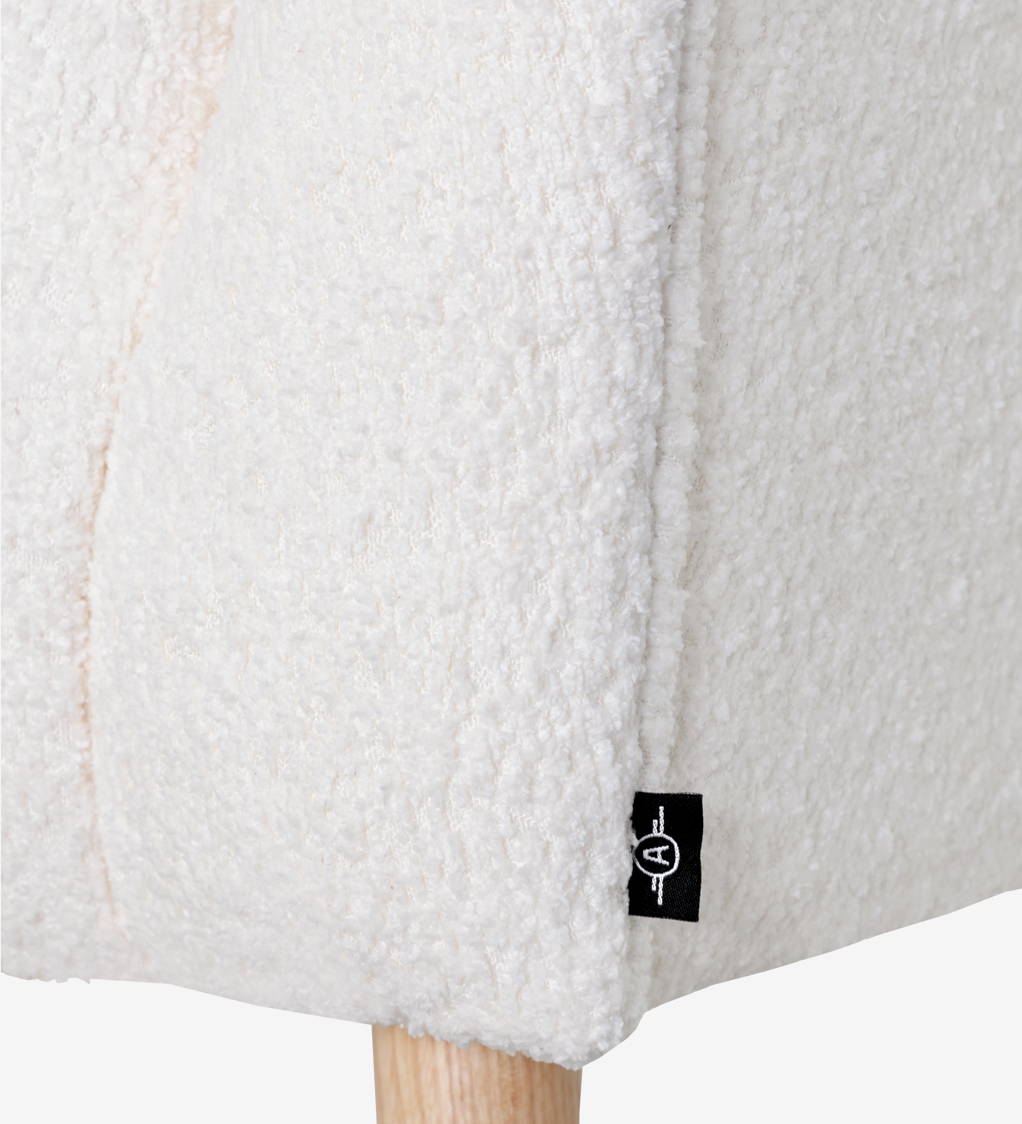 Cadeirão Tokyo estofado a tecido branco com pés em madeira cor natural.