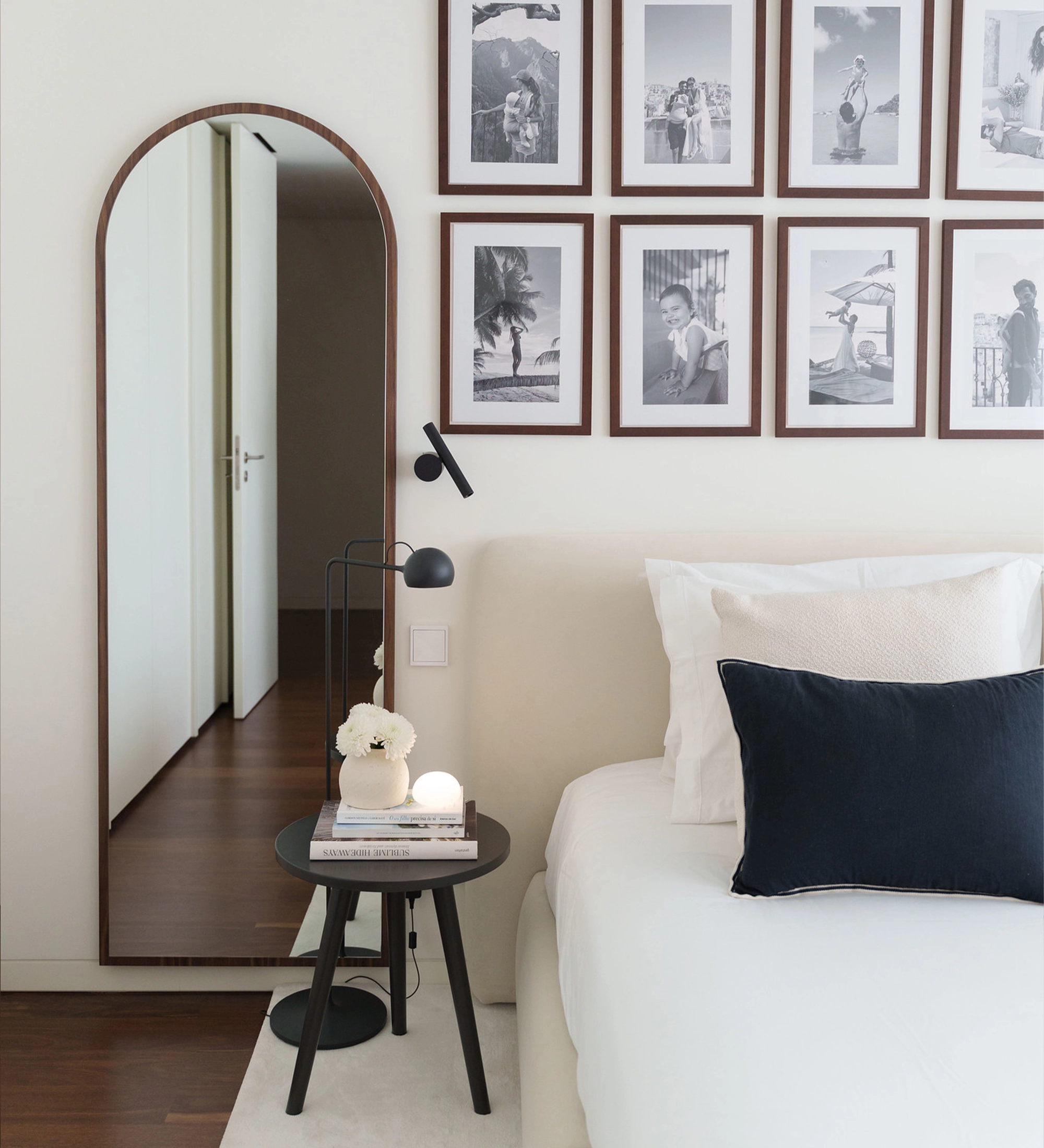 Miroir Haut Cannes en arc près d'un lit avec table de chevet et cadre photo mural