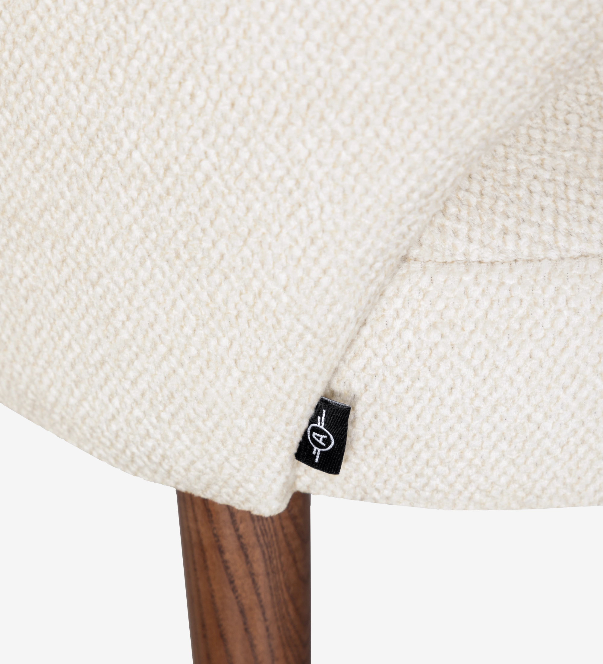 Assise crème texturée en tissu avec étiquette noire et pied en bois