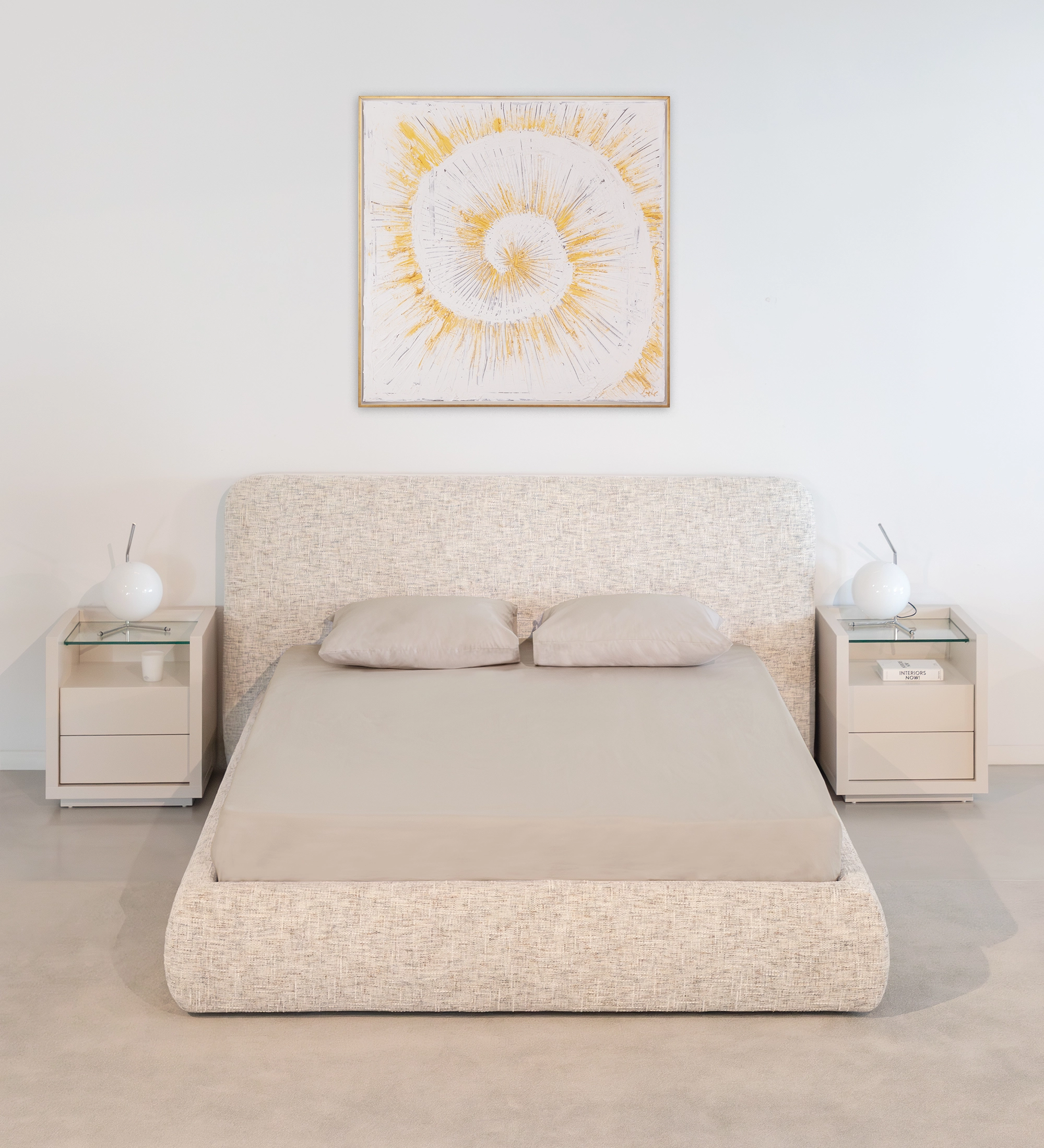 Cama de Casal Paris estofada bege com cabeceira curva, roupa cinzenta e mesas de cabeceira