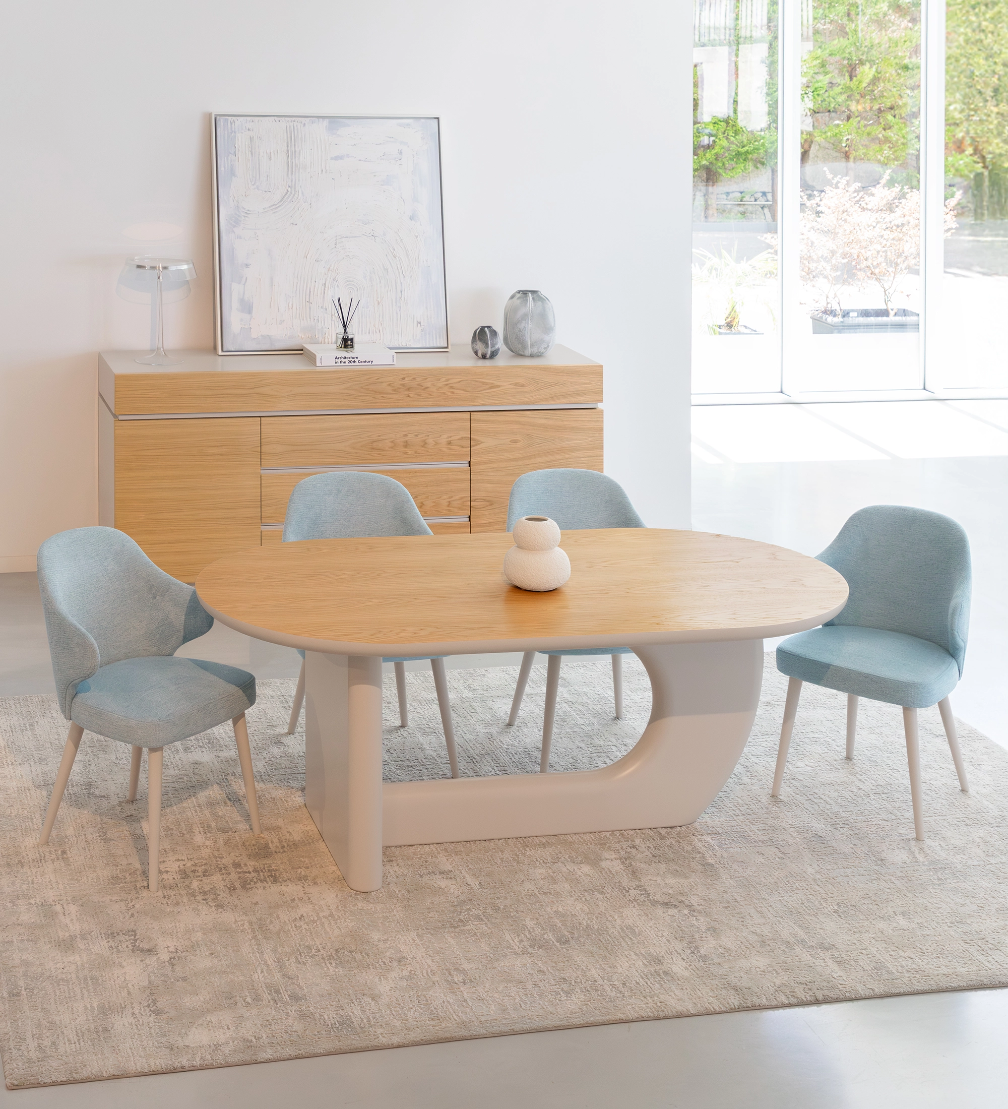 Tapete ARTISAN 300 cinzento claro sob mesa de jantar oval e cadeiras azuis