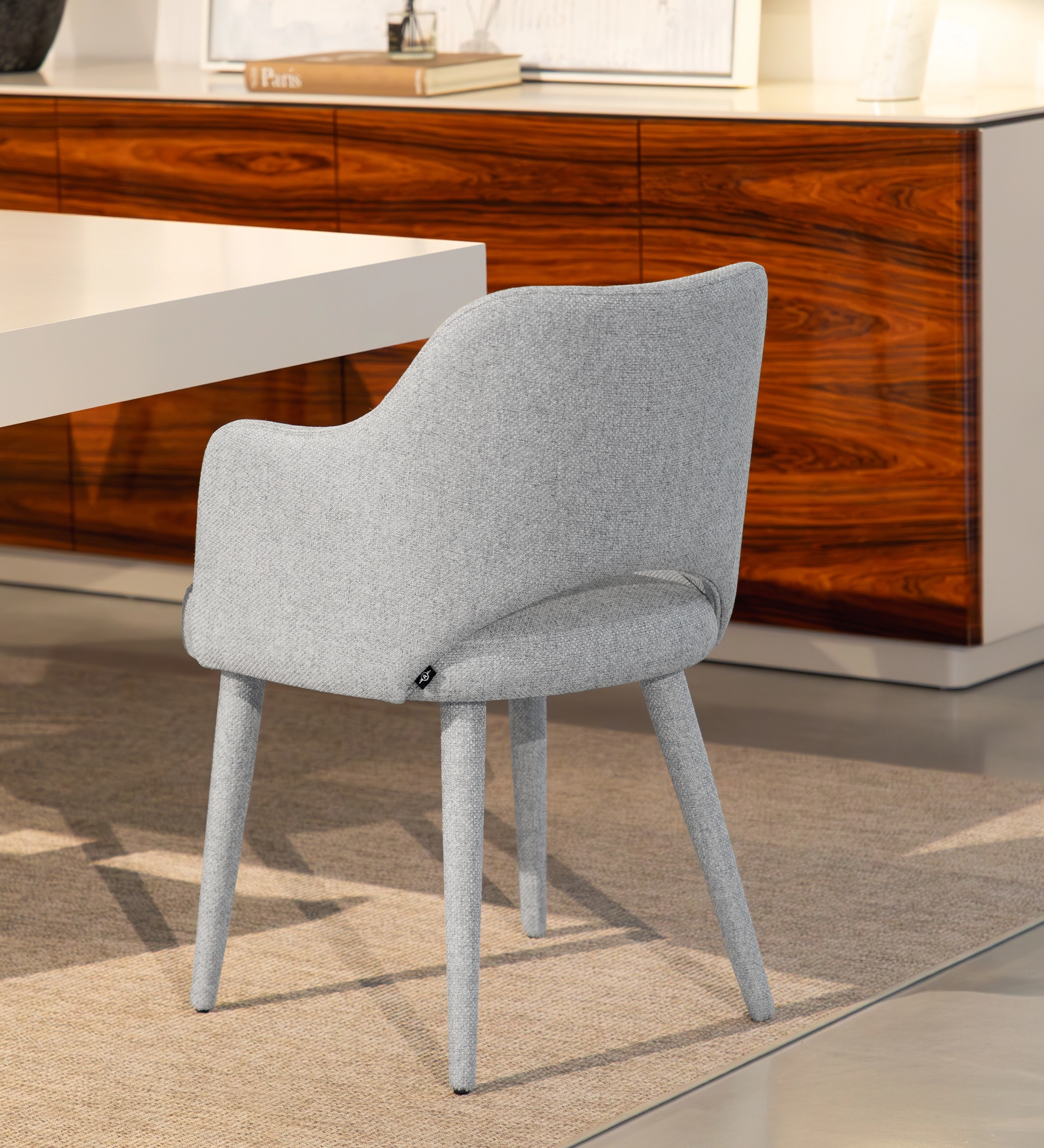 Cadeira com braços estofada a tecido cinzento.