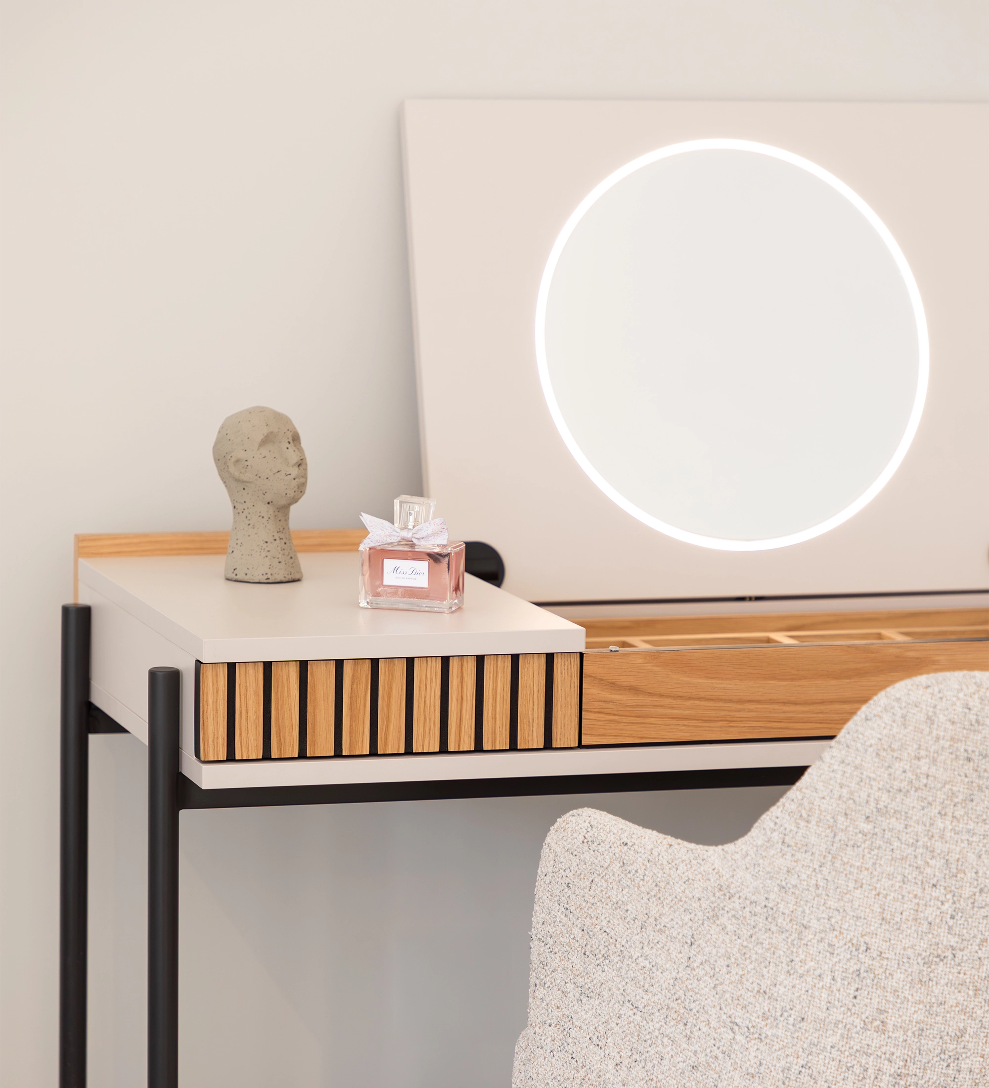 Tocador Cannes con espejo circular iluminado, botella de perfume y silla tapizada