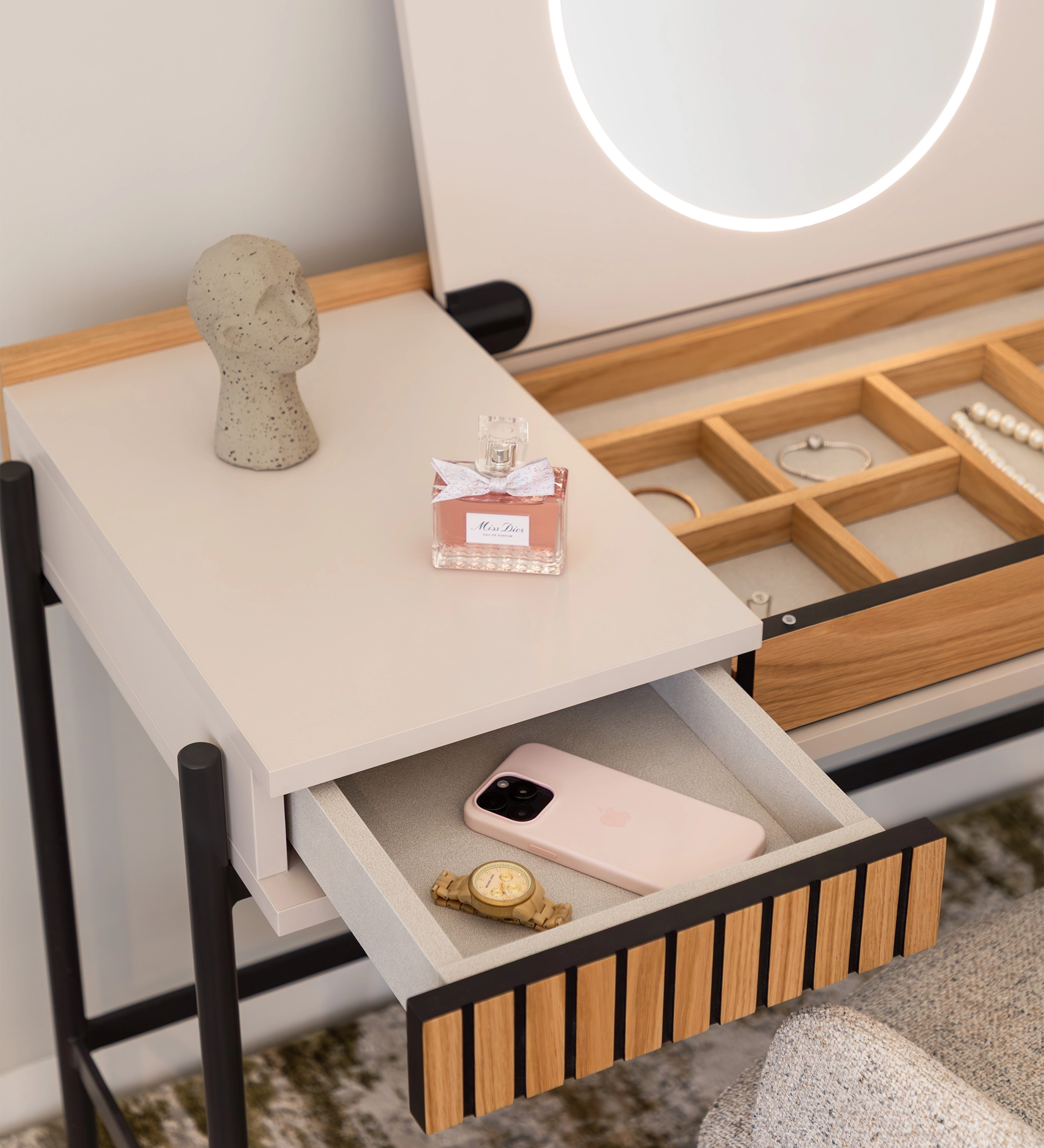 Tocador Cannes con espejo iluminado, cajón abierto con móvil, reloj y frasco de perfume