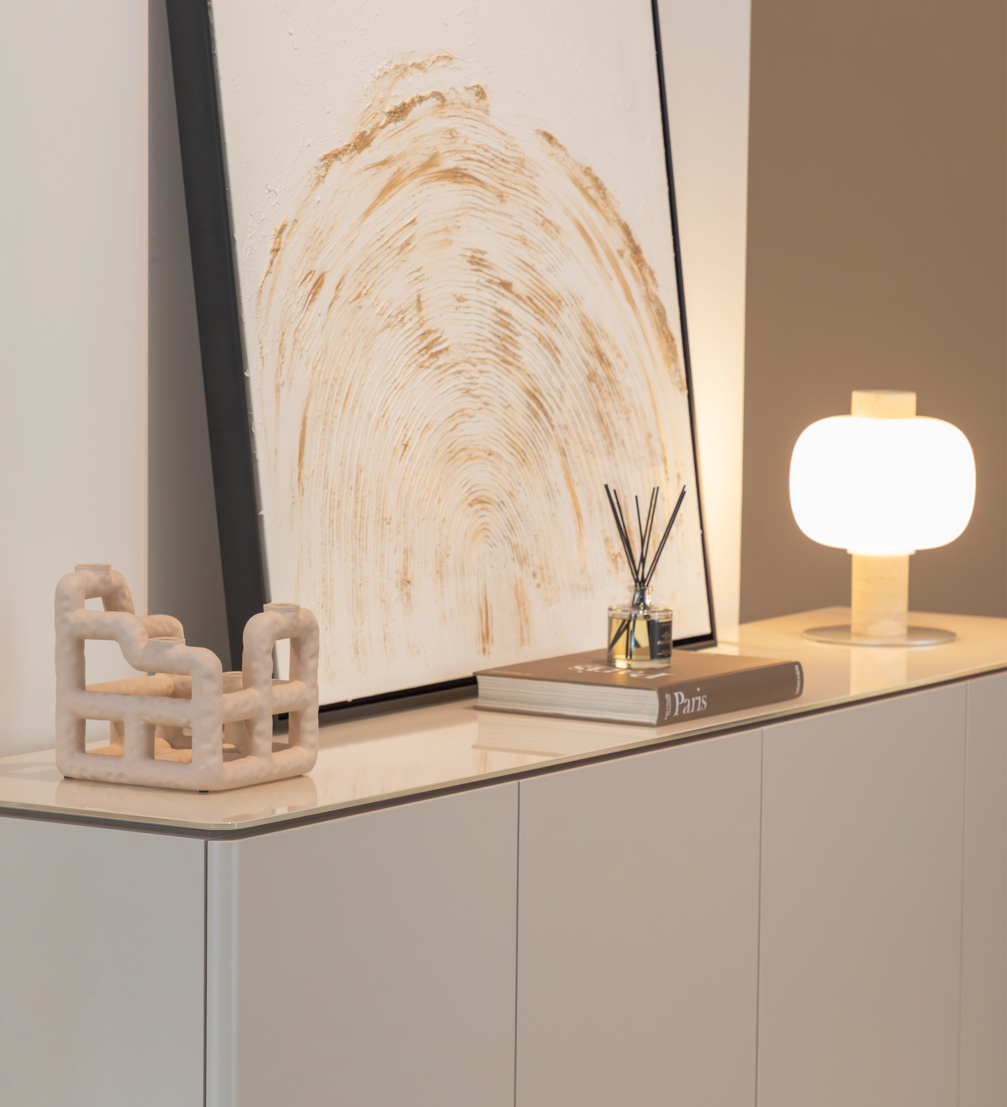Aparador Geneve blanco con lámpara, cuadro abstracto, difusor y escultura decorativa