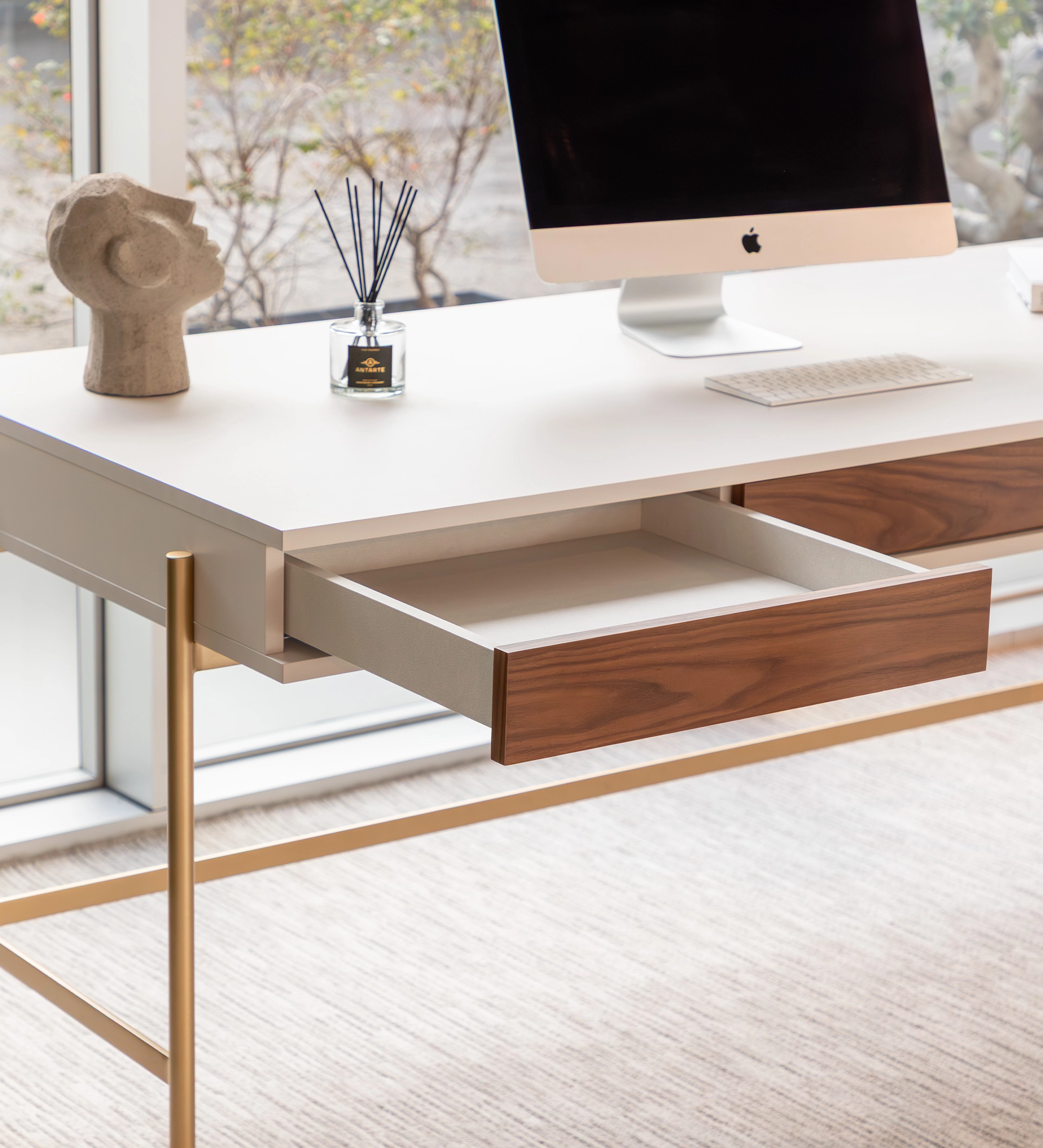 Secretaria Cannes mesa blanca con cajón de madera, patas doradas y monitor