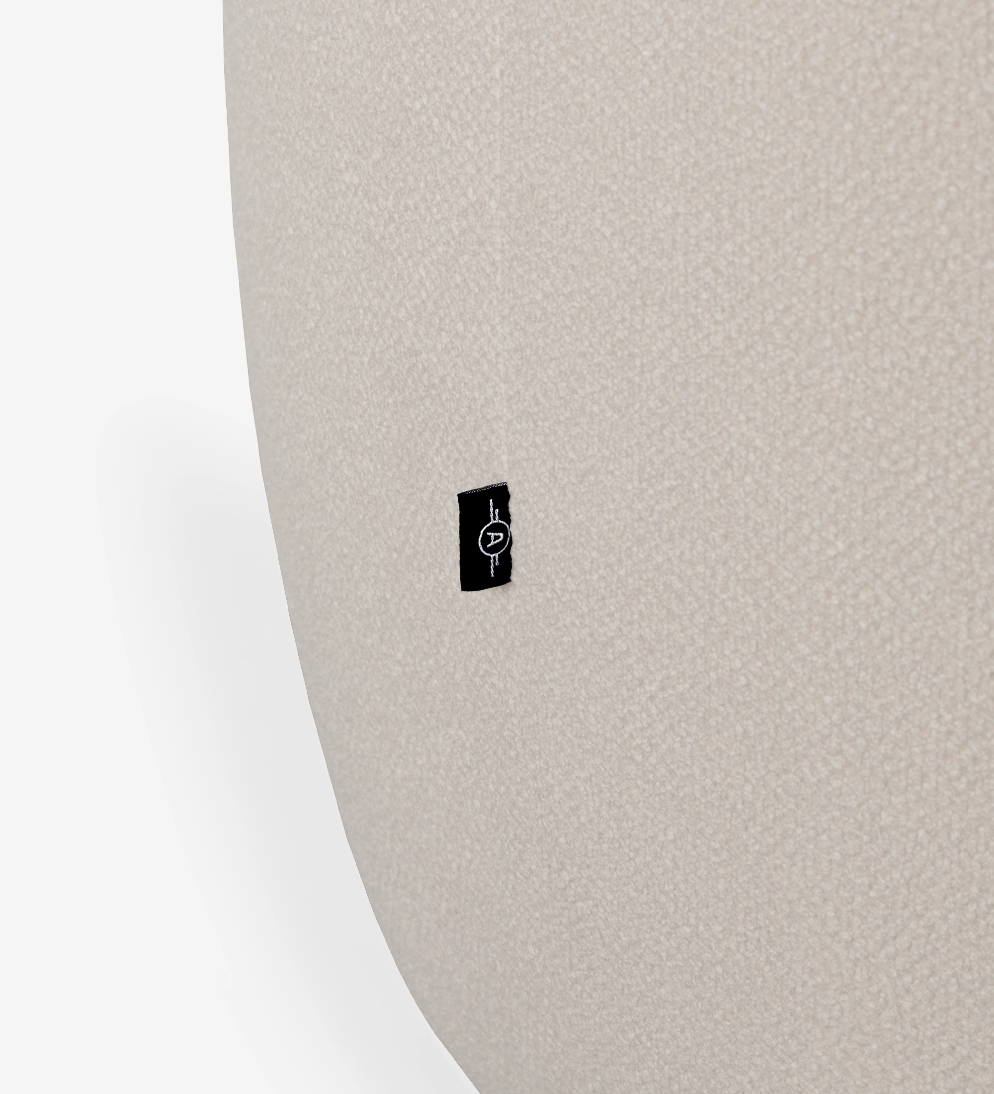Zoom sur tissu bouclé beige du Fauteuil Monaco avec étiquette noire