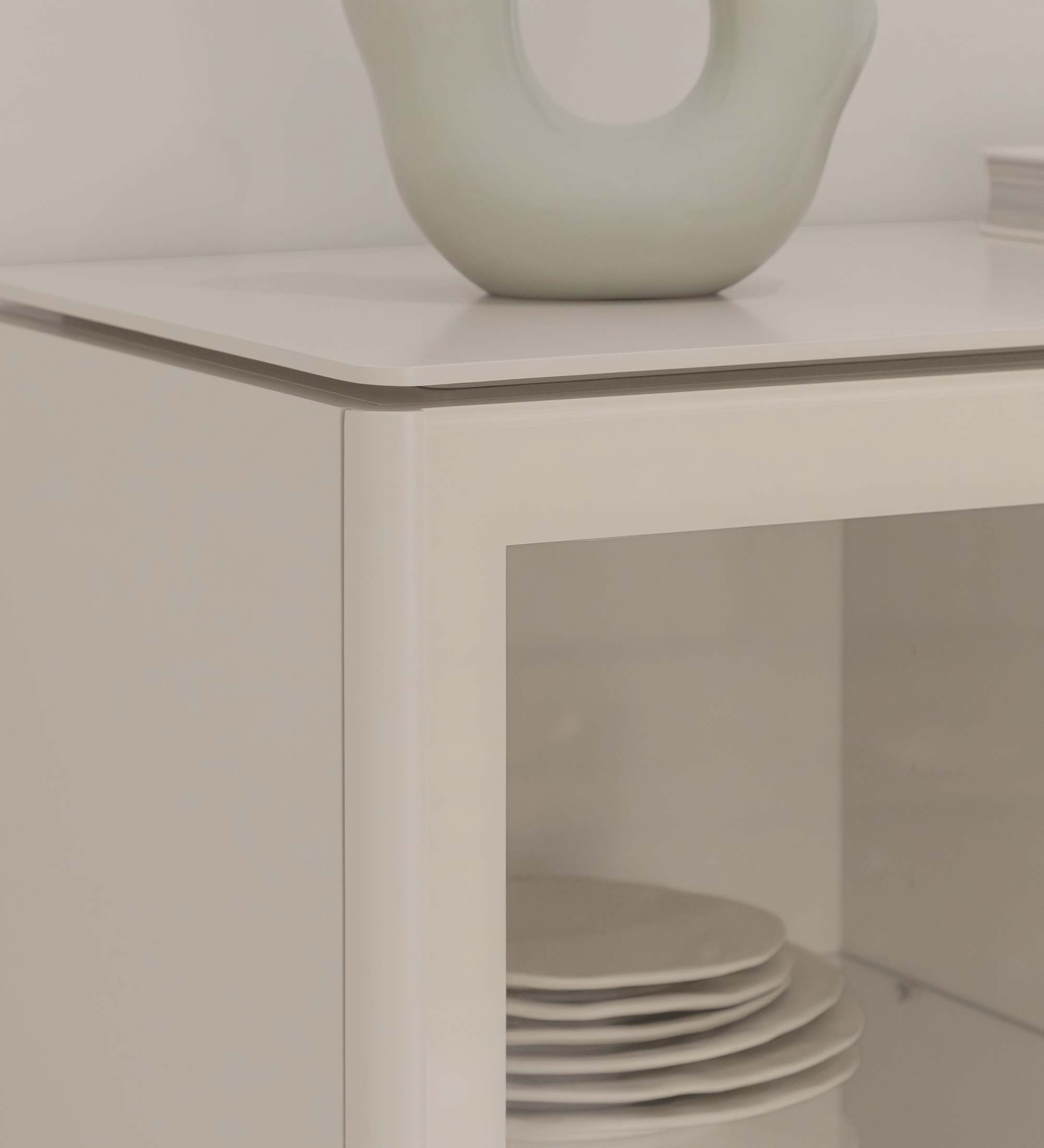 Vitrine Geneve branca com porta de vidro, pratos empilhados e vaso no topo