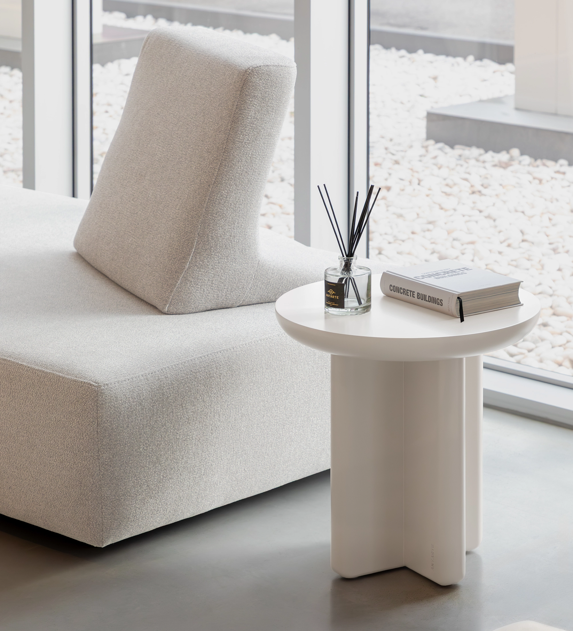 Mónaco Side Table white round side table with diffuser and book by grey sofa