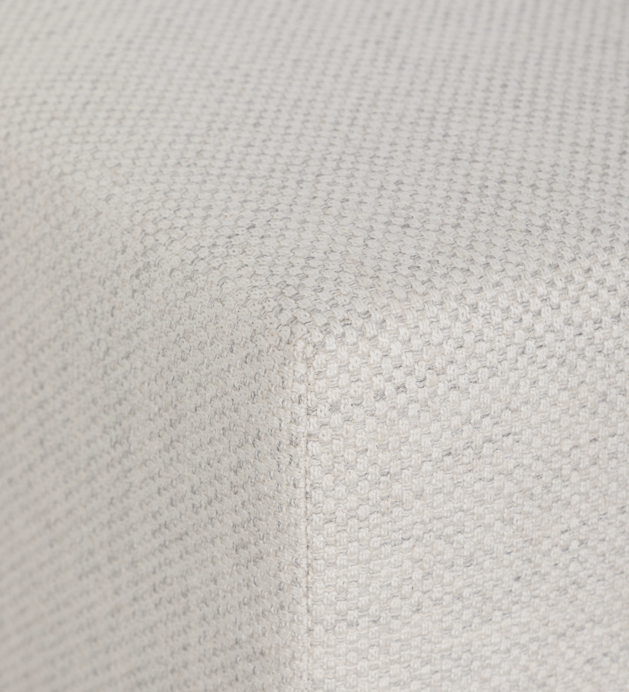 Pouf Nice en tissu beige clair texturé, gros plan sur le coin et la couture